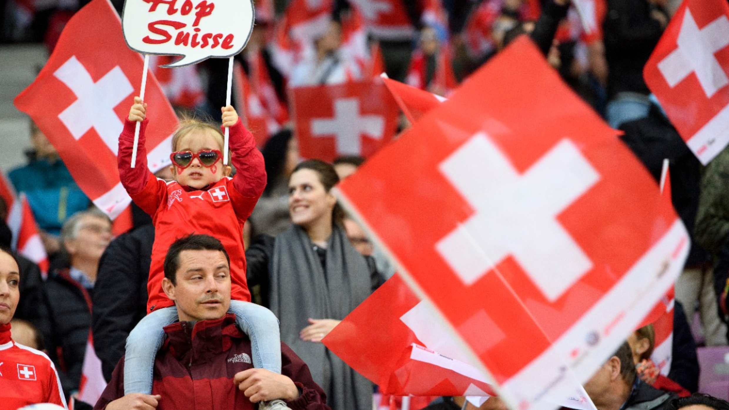 Swiss fans cheer with swiss flags during the 2018 Fifa World Cup Russia group B qualification soccer match between Switzerland and Latvia, at the stade de Geneve stadium, in Geneva, Switzerland, Saturday, March 25, 2017. (KEYSTONE/Laurent Gillieron)