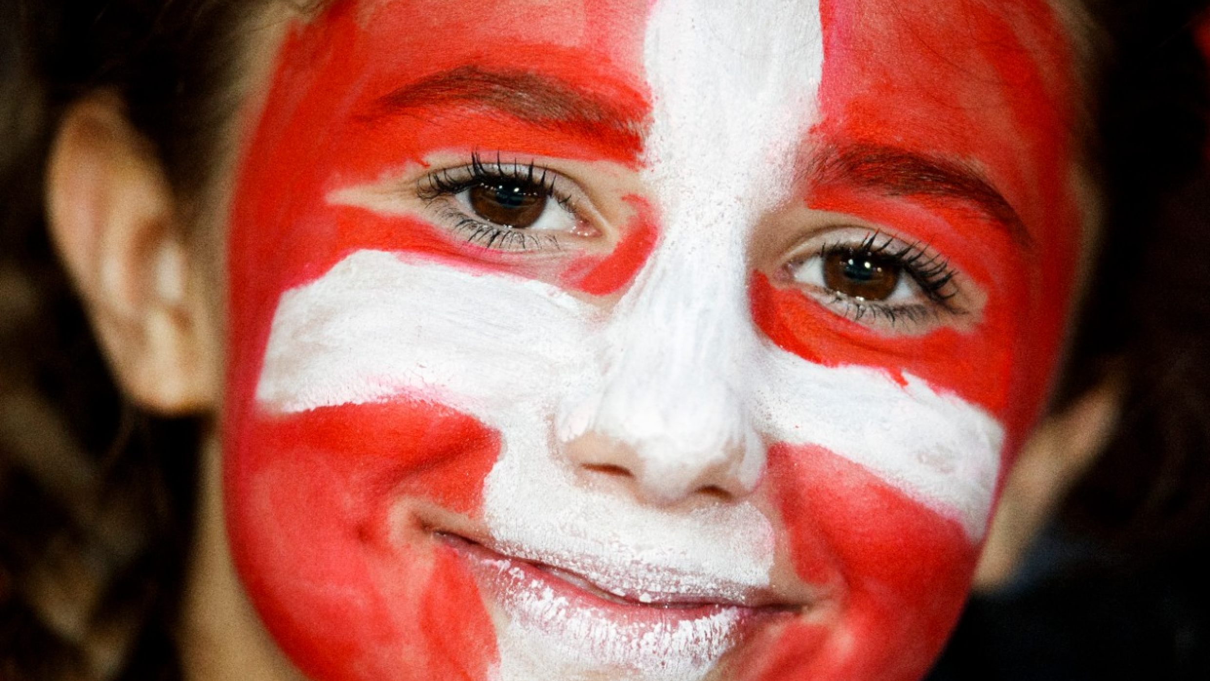 A young fan with Swiss flag makeup smiles during a friendly soccer match on the side line of the 2018 Fifa World Cup group B qualification between Switzerland and Belarus at the Stadium Maladiere, in Neuchatel, Switzerland, Thursday, June 1, 2017. (KEYSTONE/Valentin Flauraud)