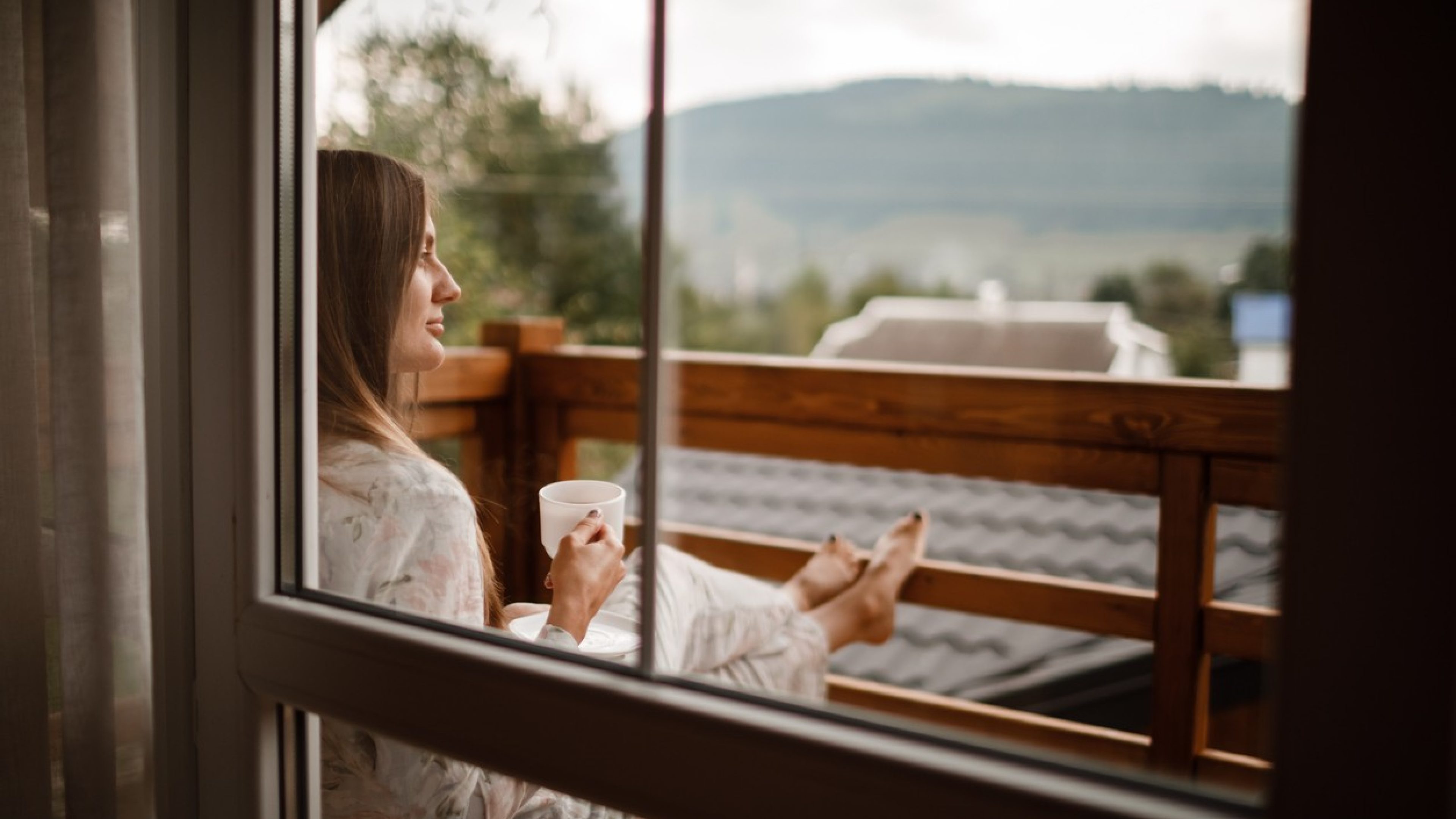 Frau sitzt auf einem Balkon 