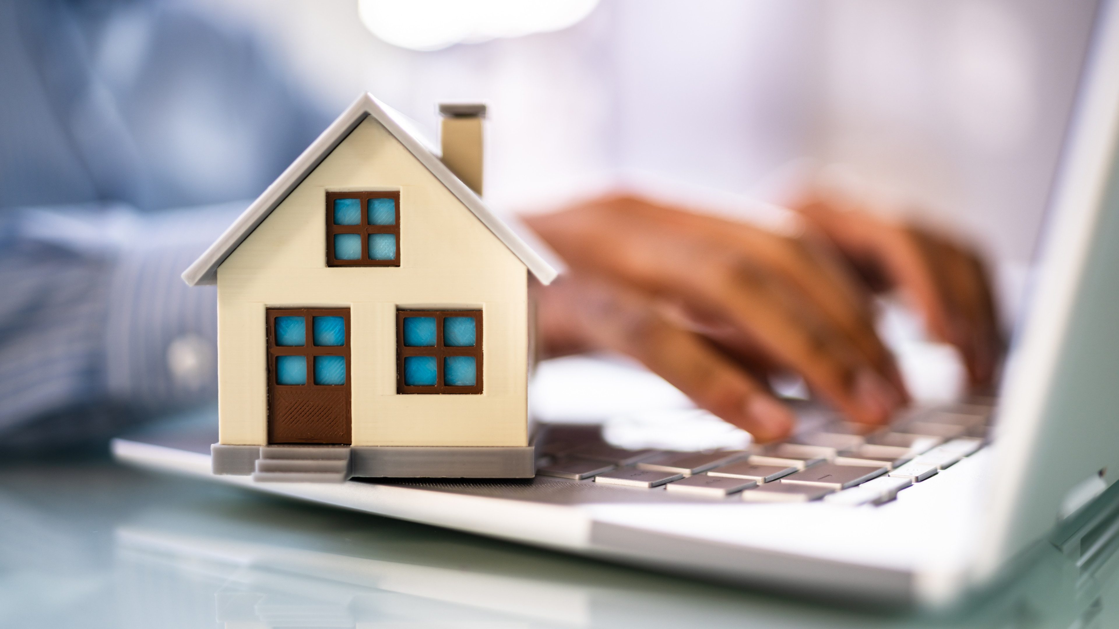 Real Estate House Model Near Laptop On Desk