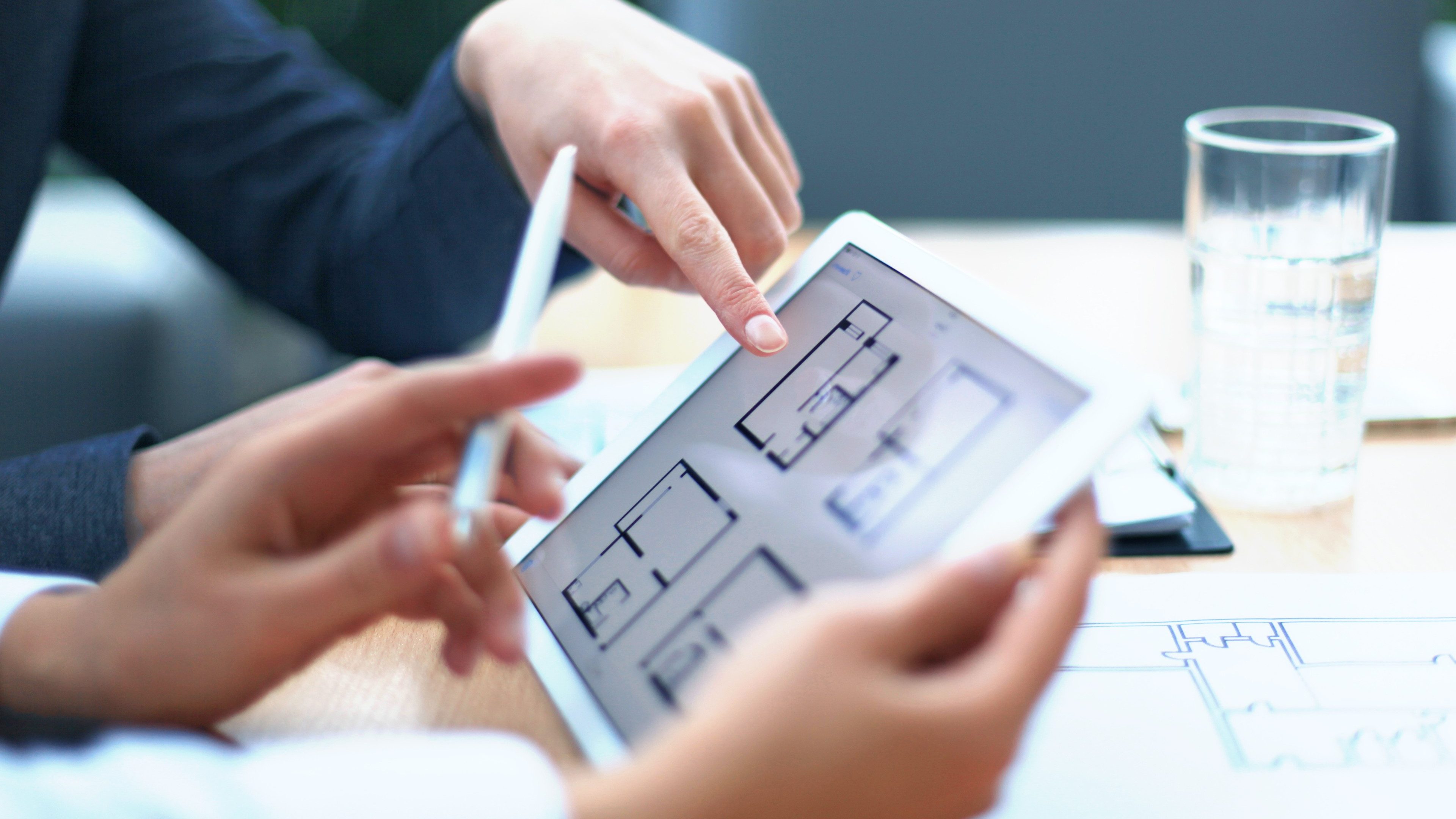 Real-estate agent showing house plans on electronic tablet