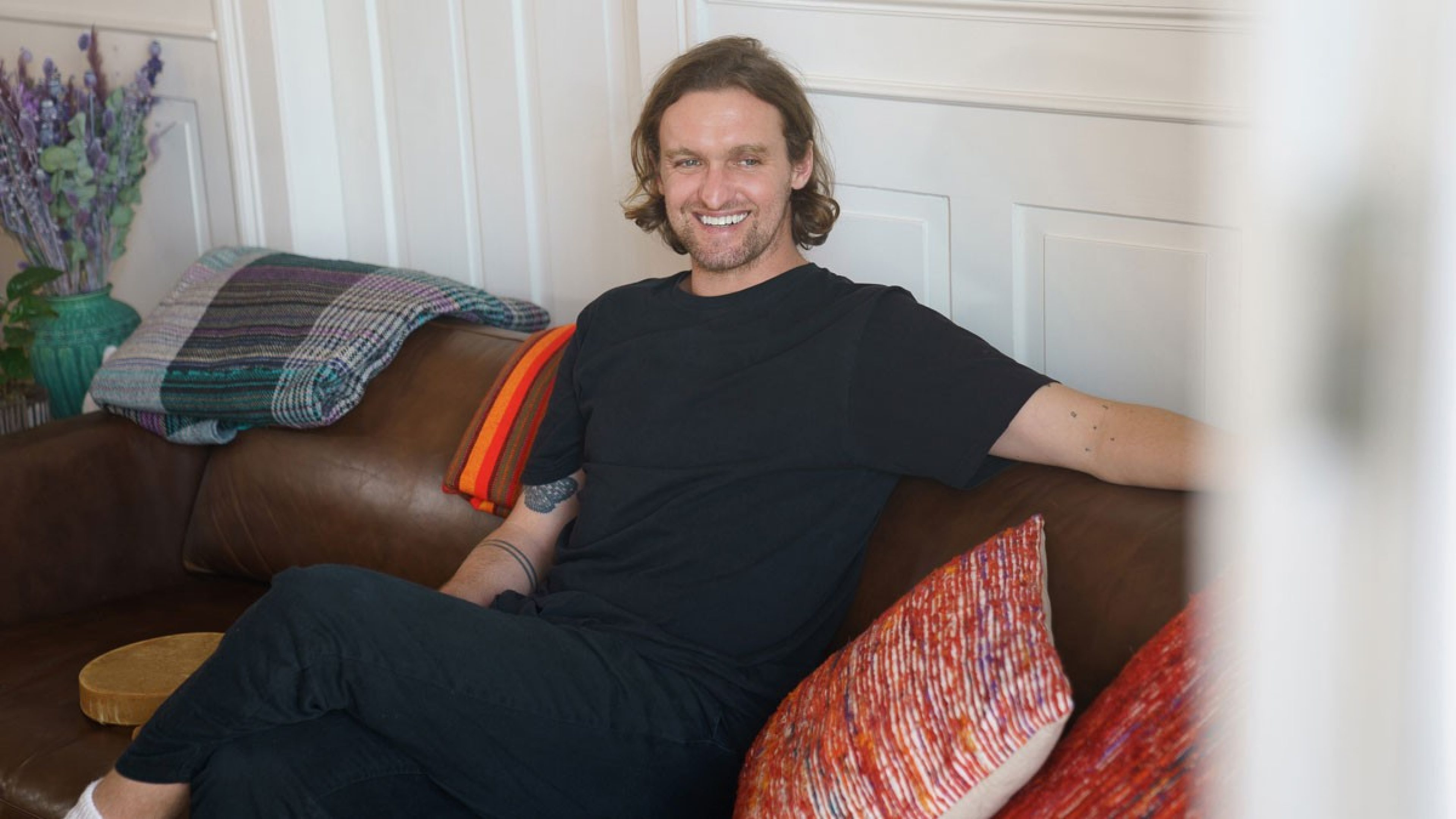 Xaver Schenker sitzt auf einem Sofa und erzählt von seinen Erlebnissen.