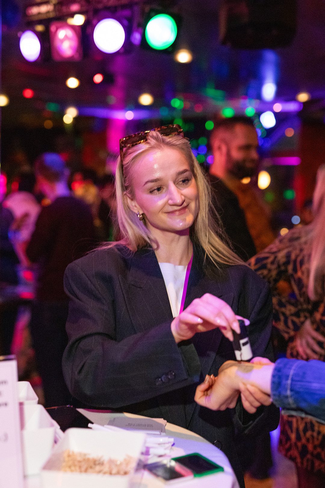 Laura Matter drückt einer Single-Frau einen Eintrittsstempel auf das Handgelenk. 