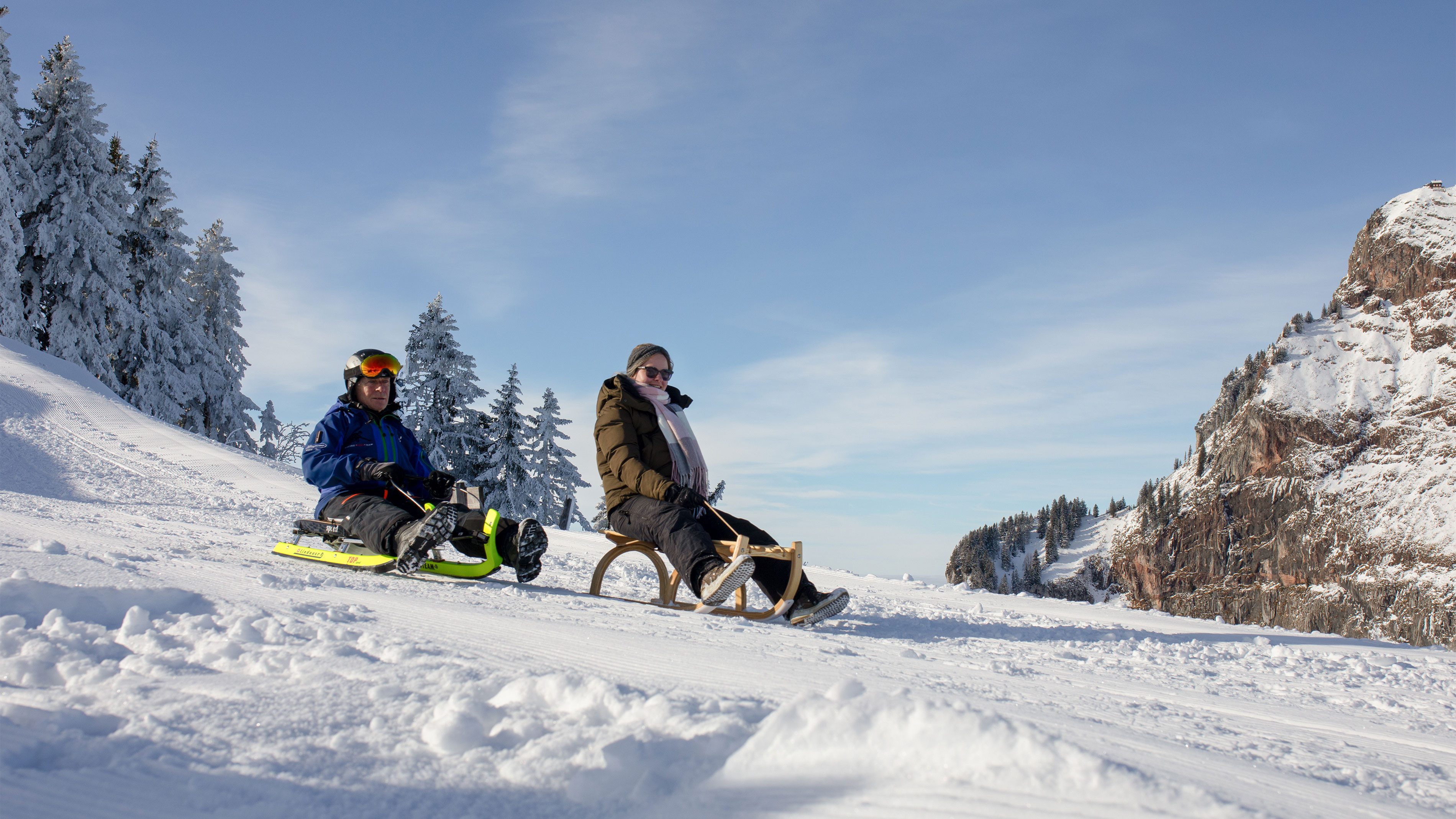 Fotografie Frau und Mann auf Schlitten im Schnee