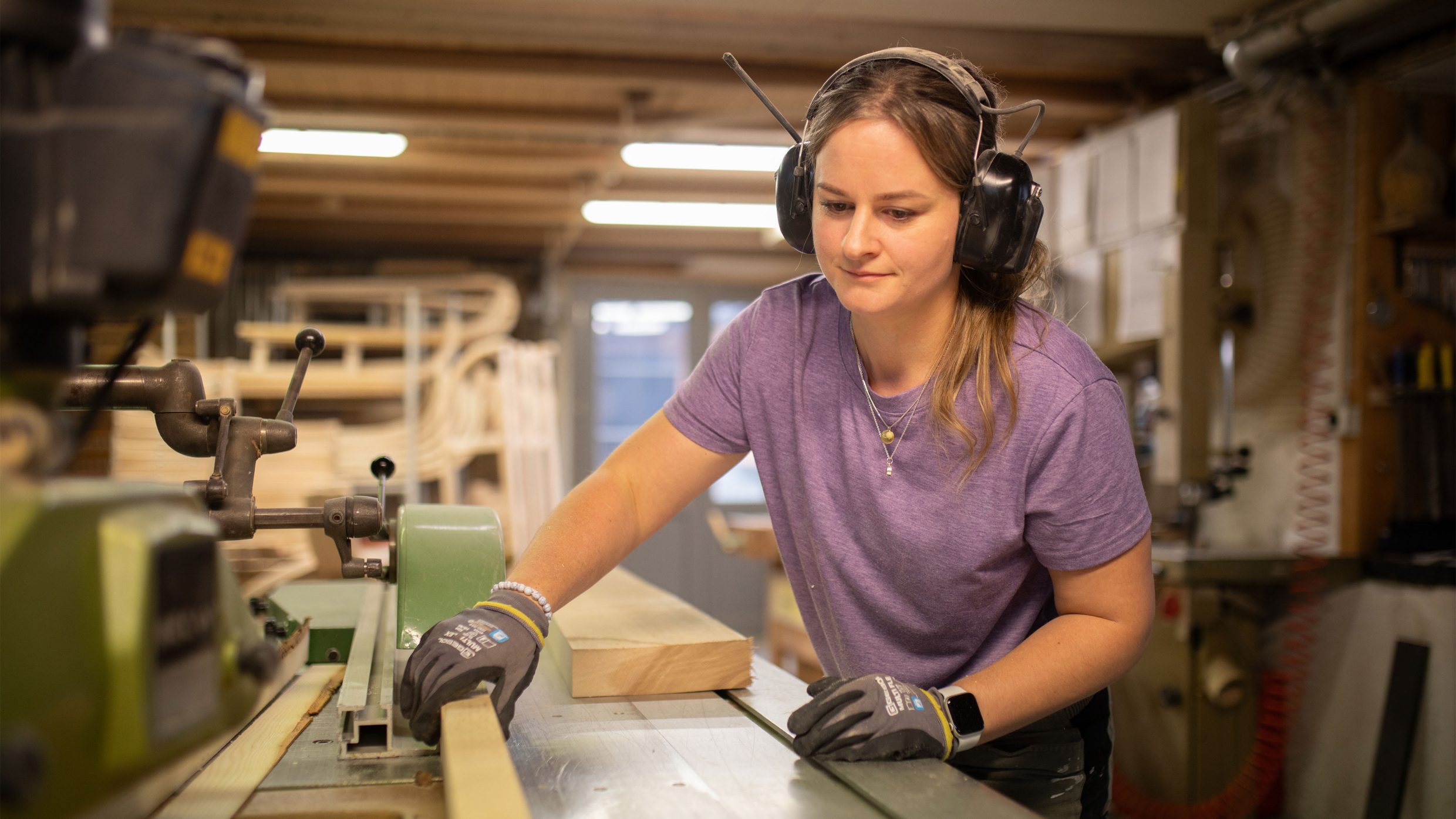 Fotografie Frau arbeitet mit Holz in einer Werkstatt