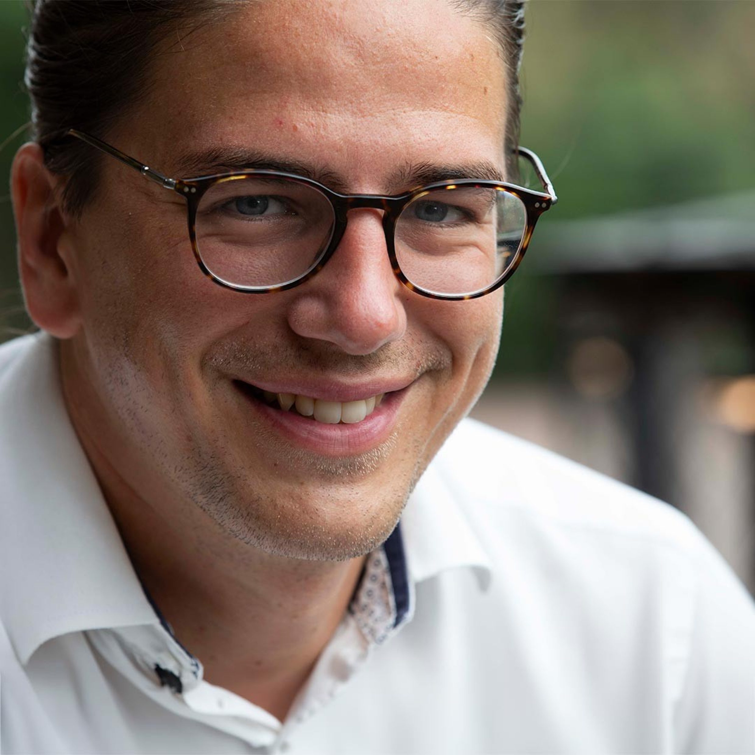 Portrait von einem lächelnden Mann mit Brille