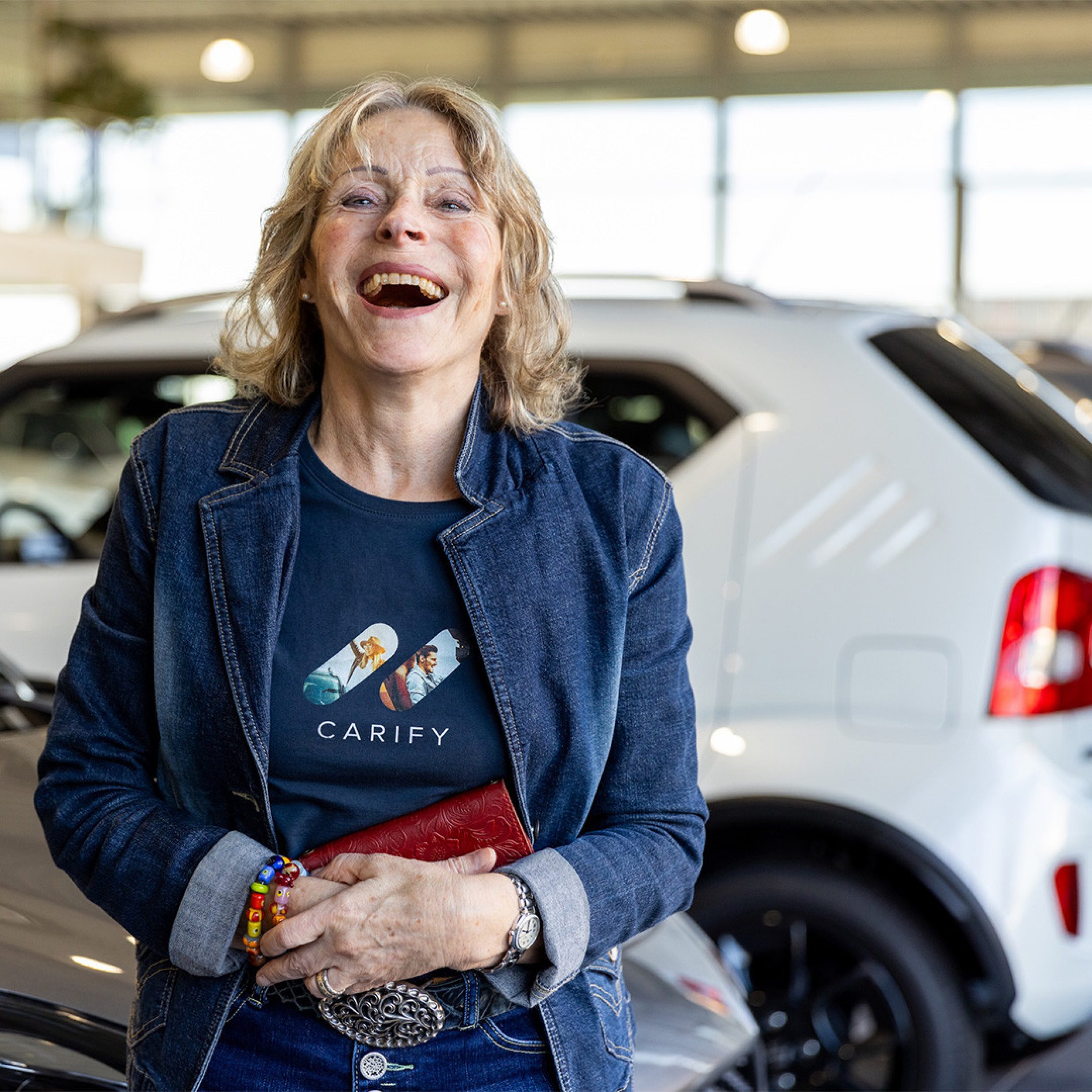 Fotografie Seniorin steht lachend in Autogarage
