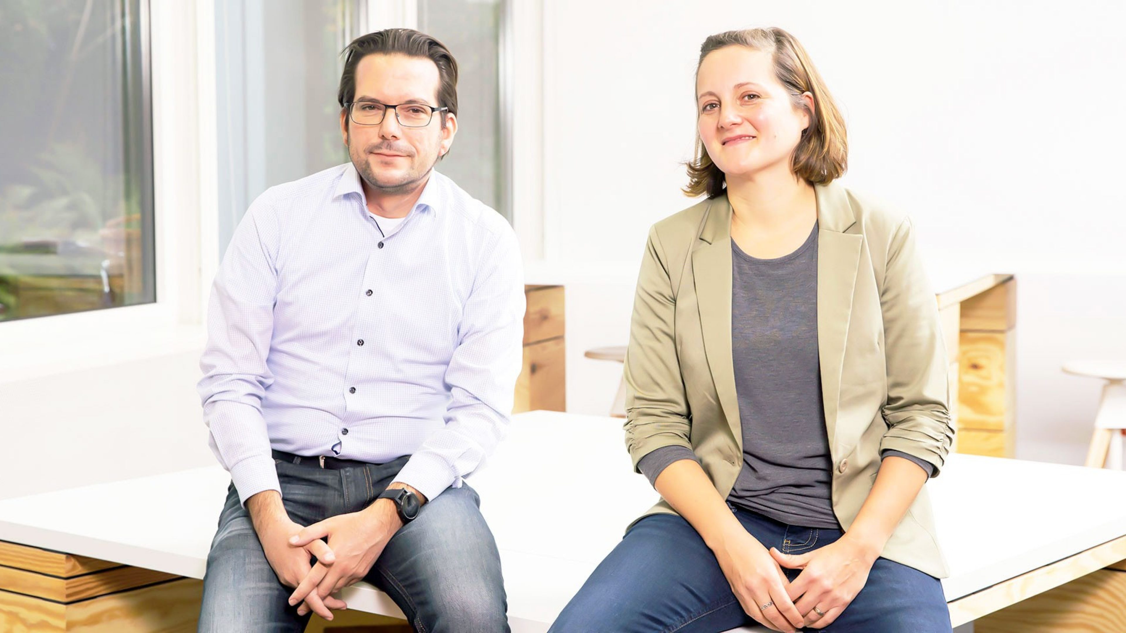 Inga Hassebroek und Andreas Müller sitzen auf einem Tisch.