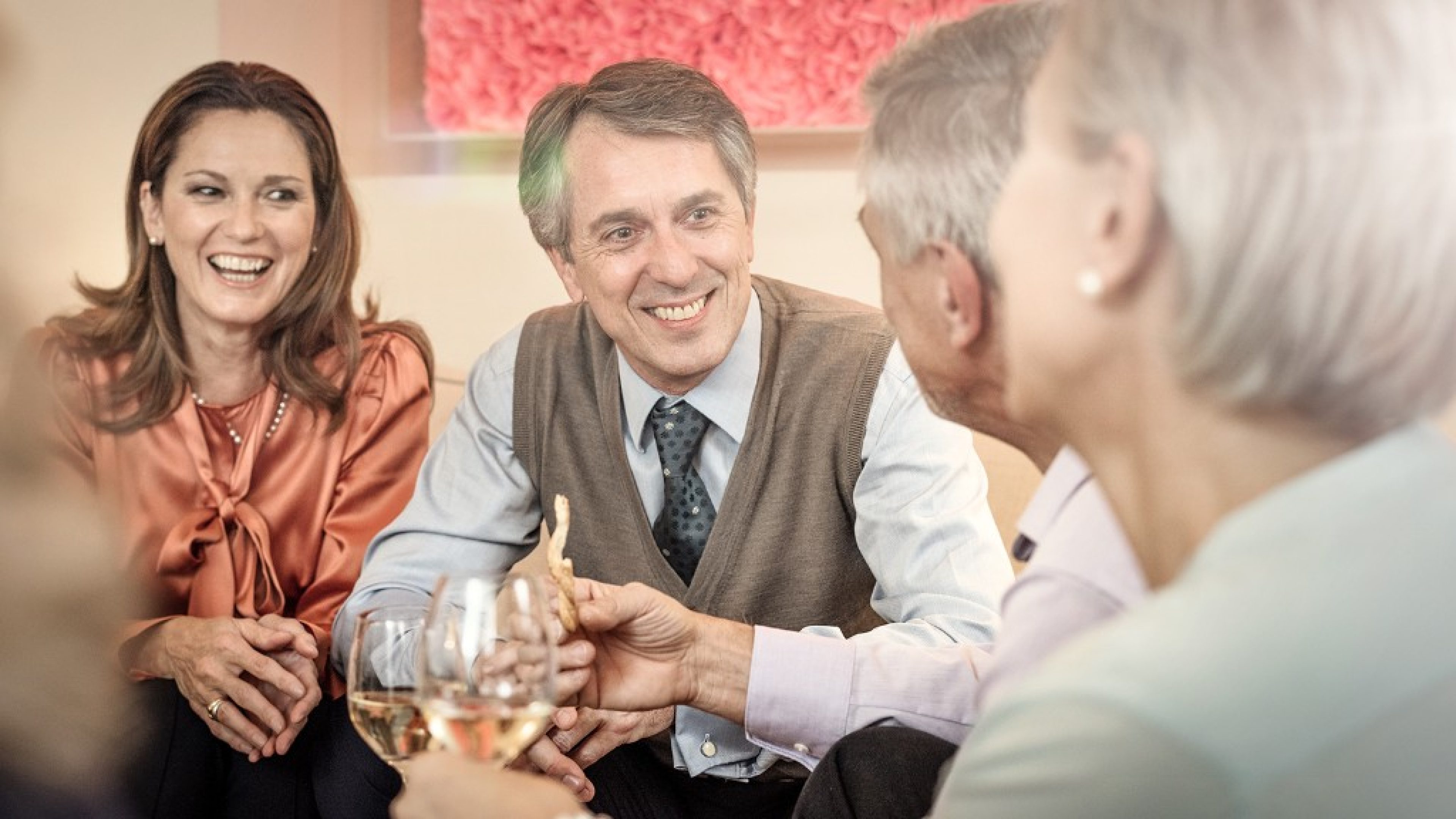 Zwei befreundete Ehepaare besprechen im Wohnzimmer die Vorbereitung auf die Pensionierung.