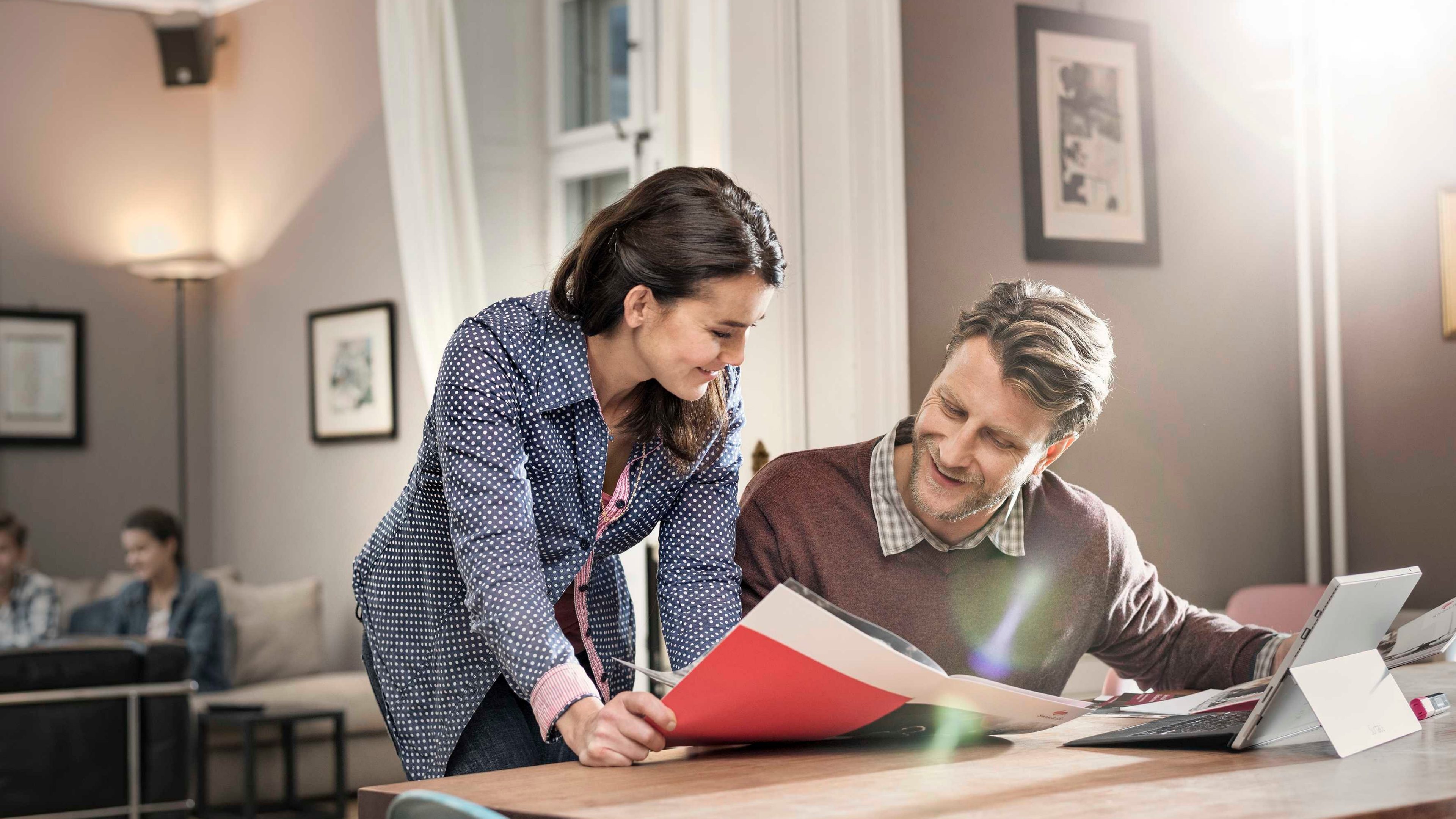 Ein Ehepaar schaut zuhause Unterlagen zu Sparversicherungen durch.