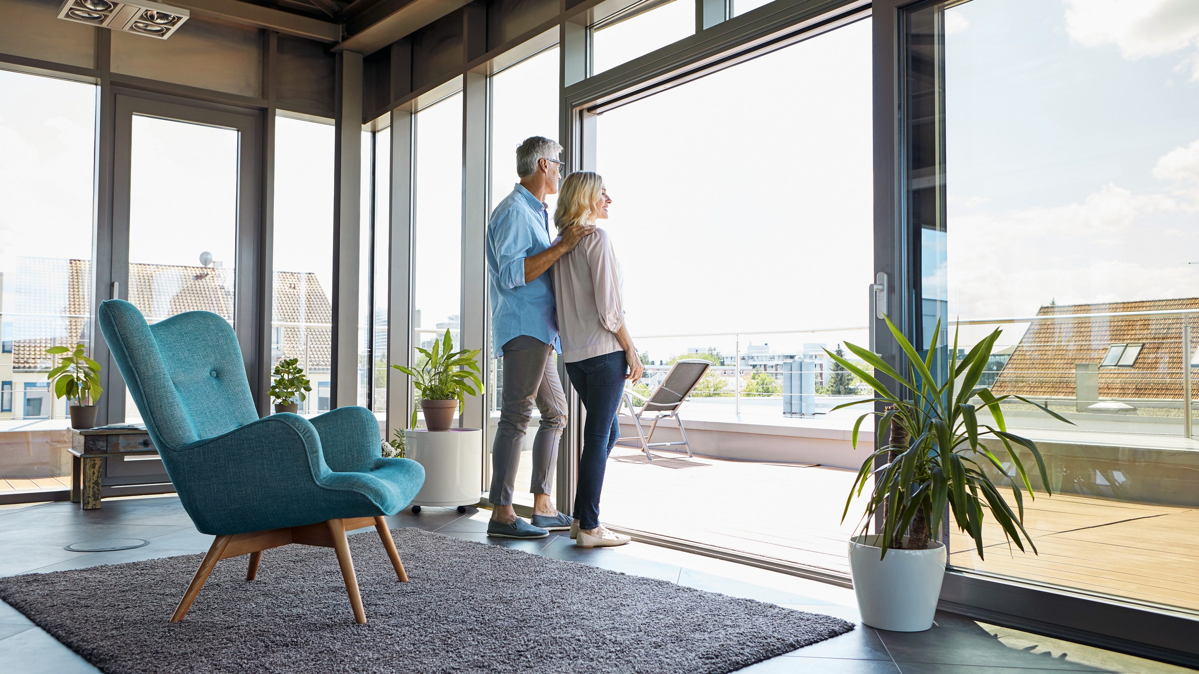 Mature couple looking out of window at home