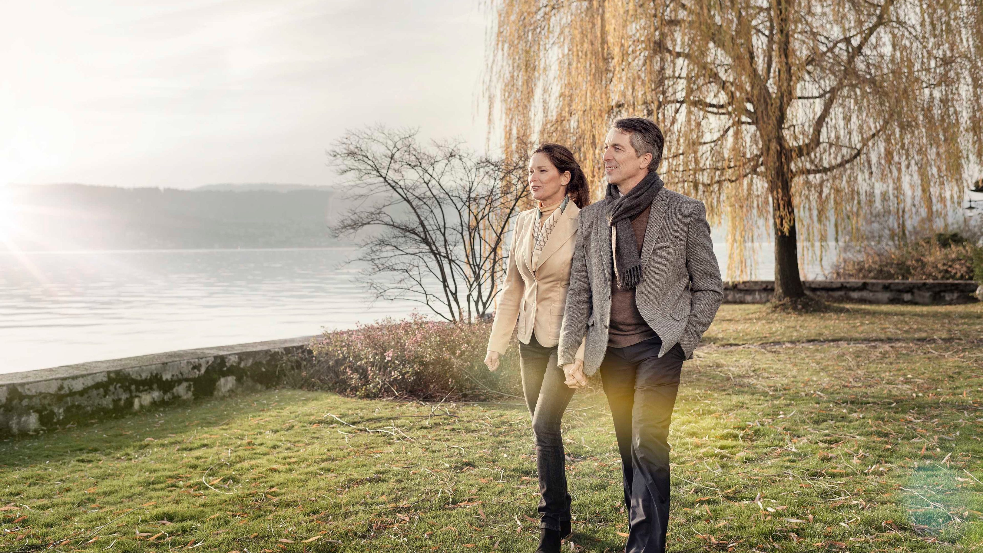 Ein Ehepaar spaziert am See und bespricht das Thema Pensionierung.