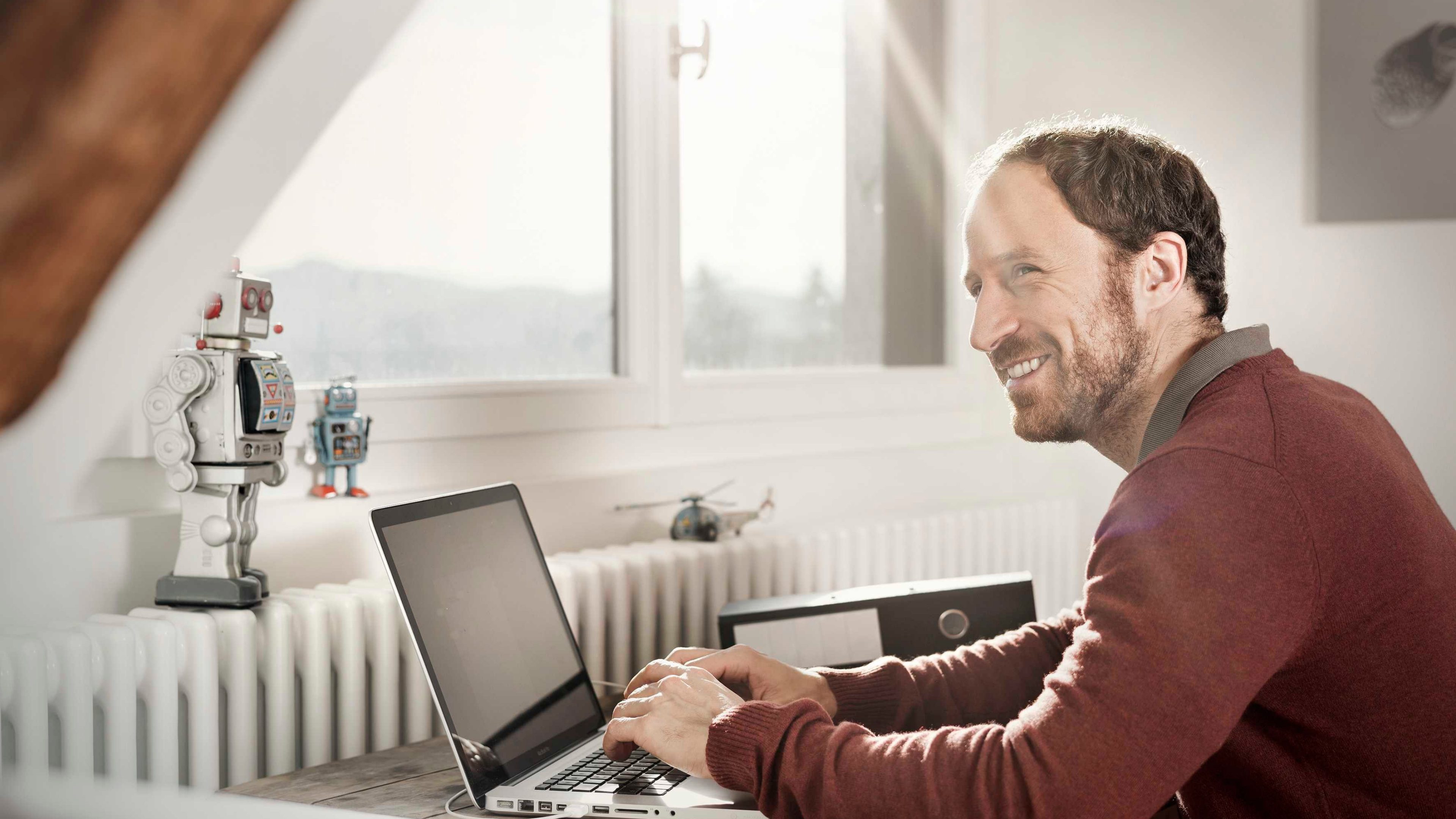 Ein Familienvater berechnet das Budget mit einem Online-Rechner am Computer. 