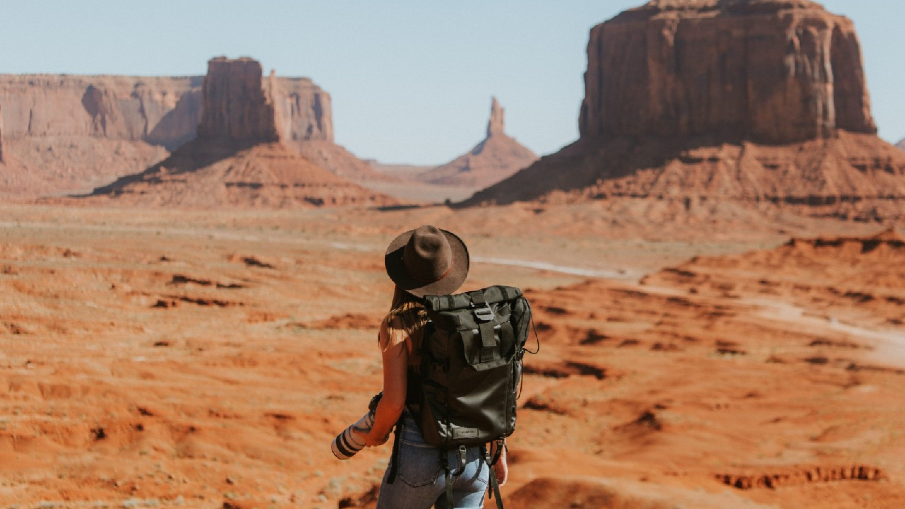 Eine Frau mit Rucksack wandert durch eine felsige Landschaft.