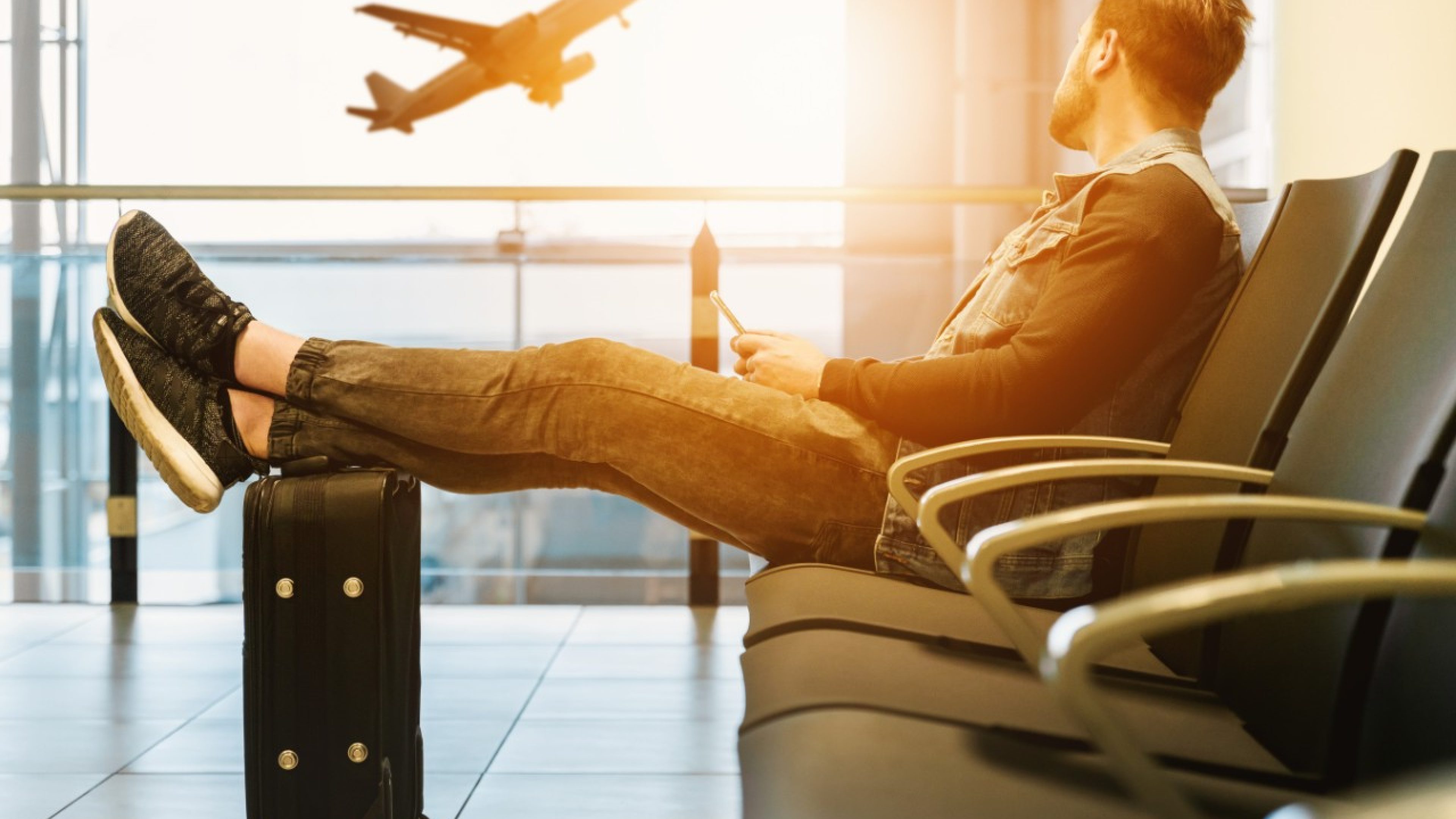 Ein Mann wartet am Flughafen auf seinen Flieger.