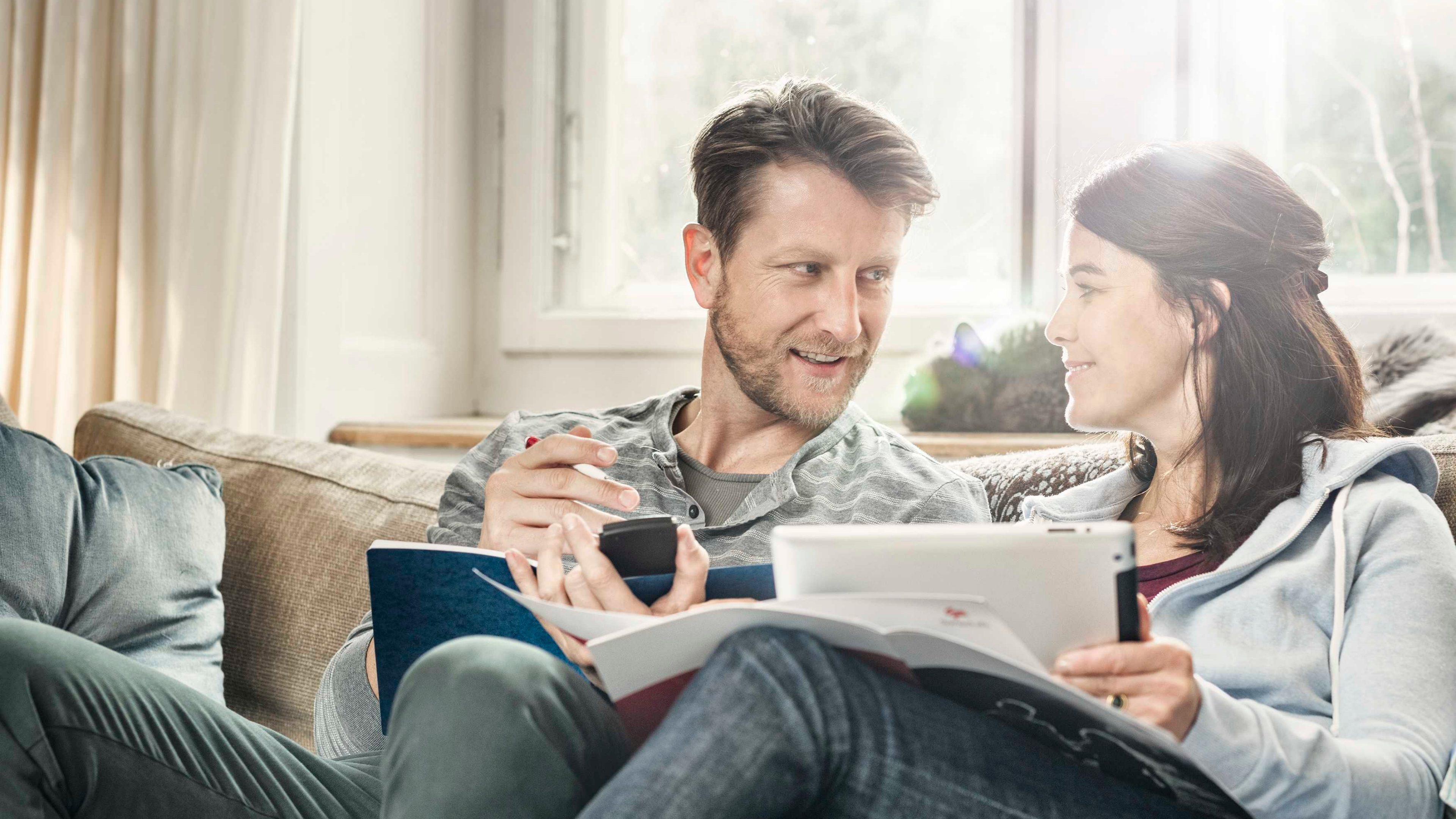 Paar sitzt auf dem Sofa und bespricht Altersvorsorge