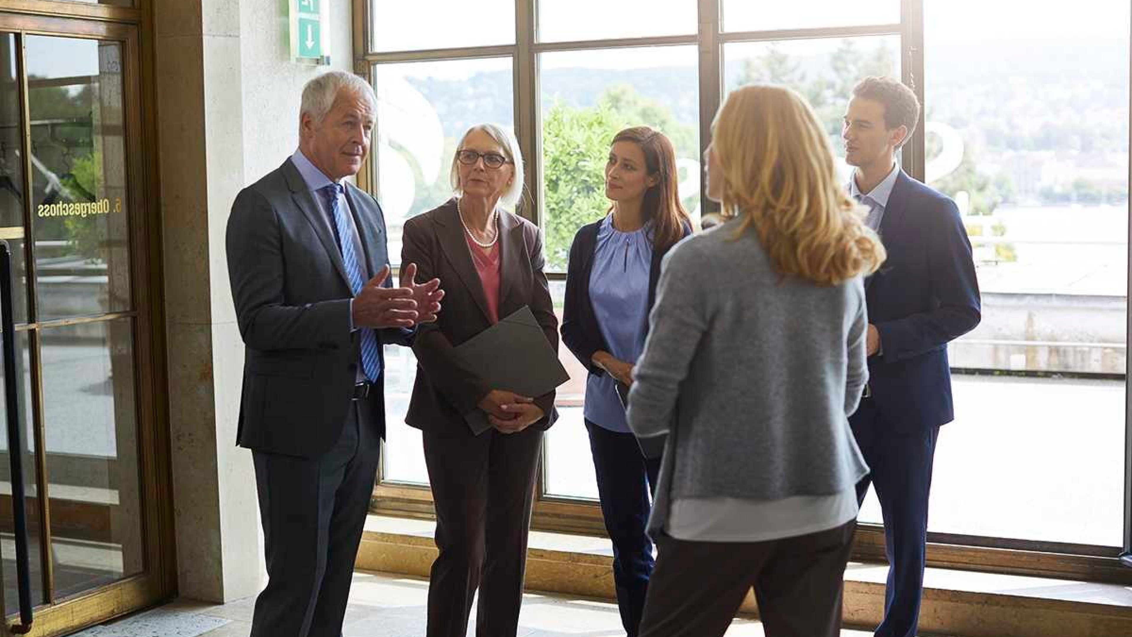 Veranstaltungsteilnehmer unterhalten sich im Bürogebäude zum Thema Personalorientierung. 