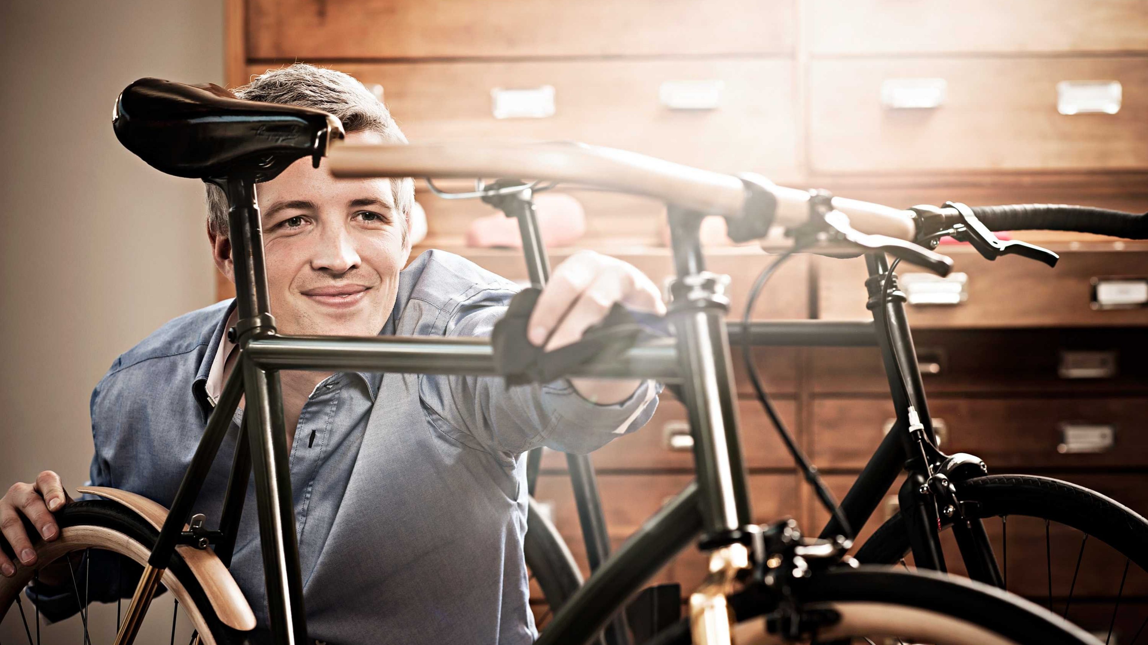 Ein Jungunternehmer arbeitet an einem Fahrrad in seiner Werkstatt.