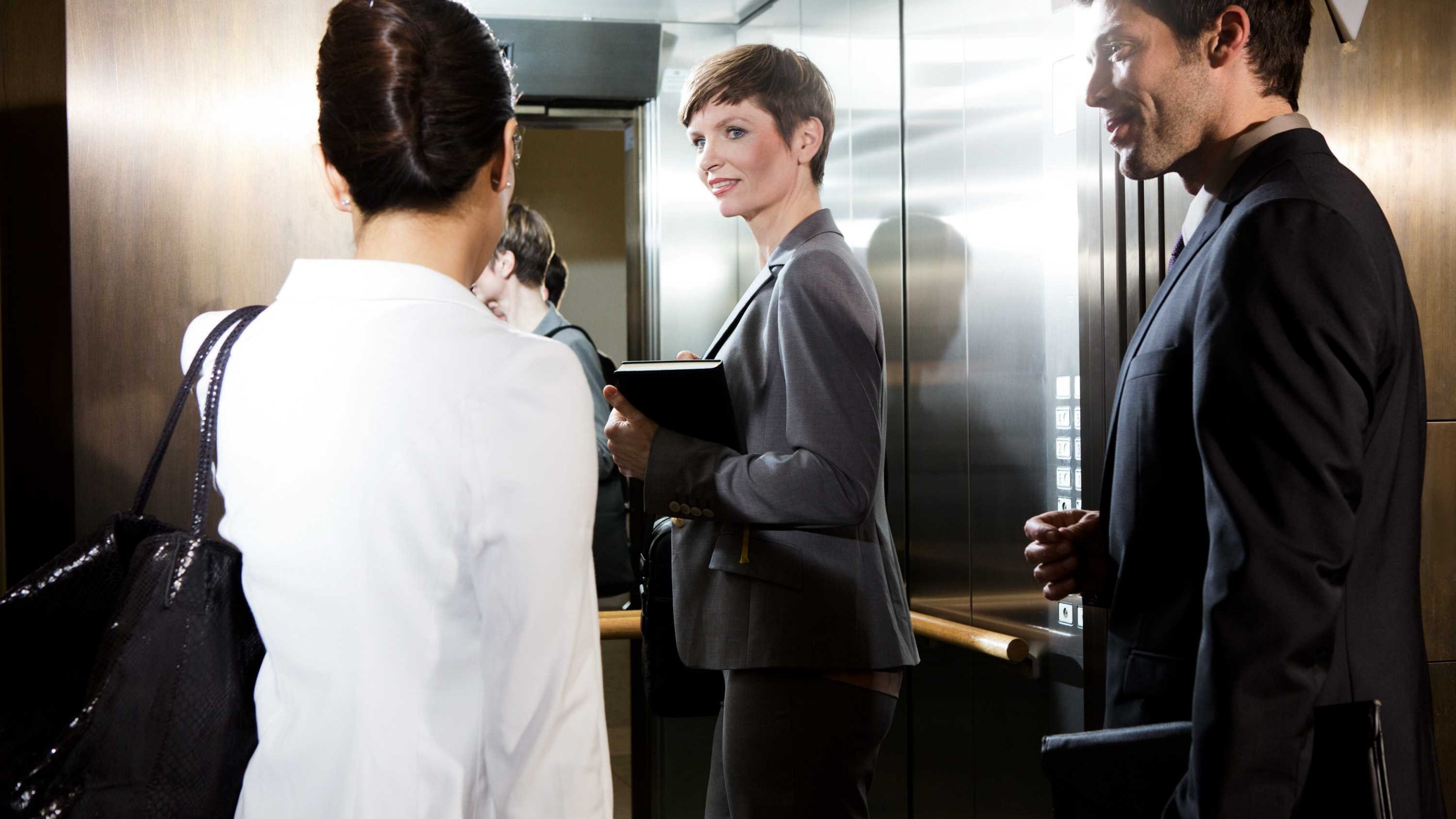 Mitarbeitende steigen auf dem Weg ins Büro in einen Lift.