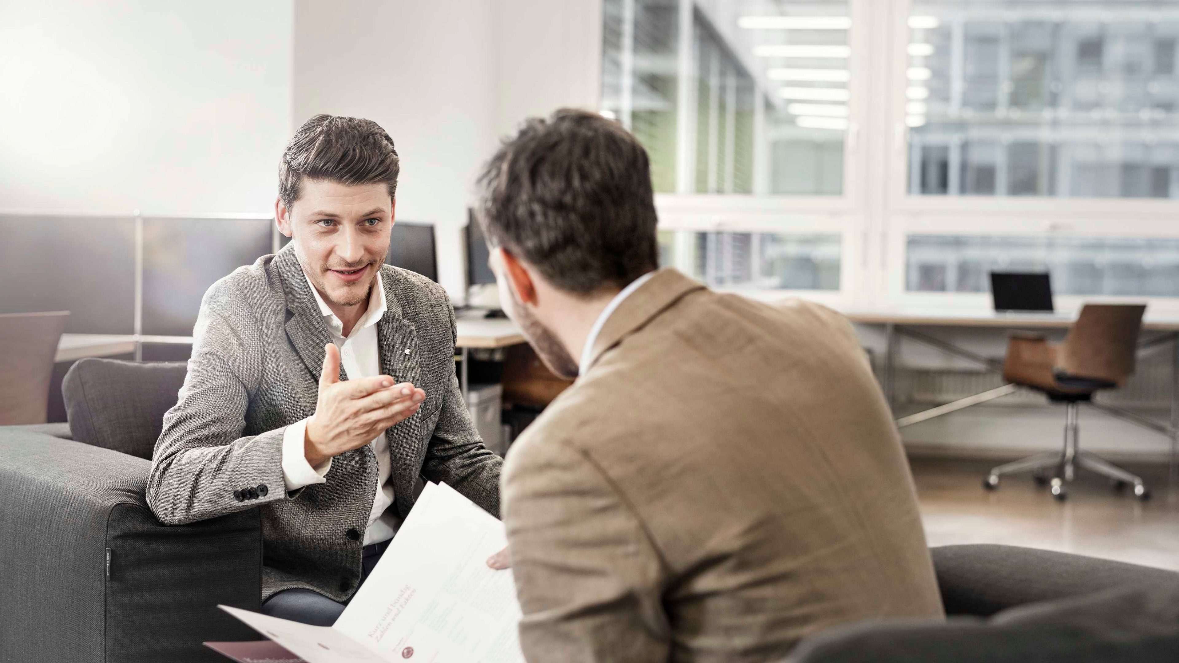 Zwei Unternehmer besprechen Pläne in ihrer Werkstatt.