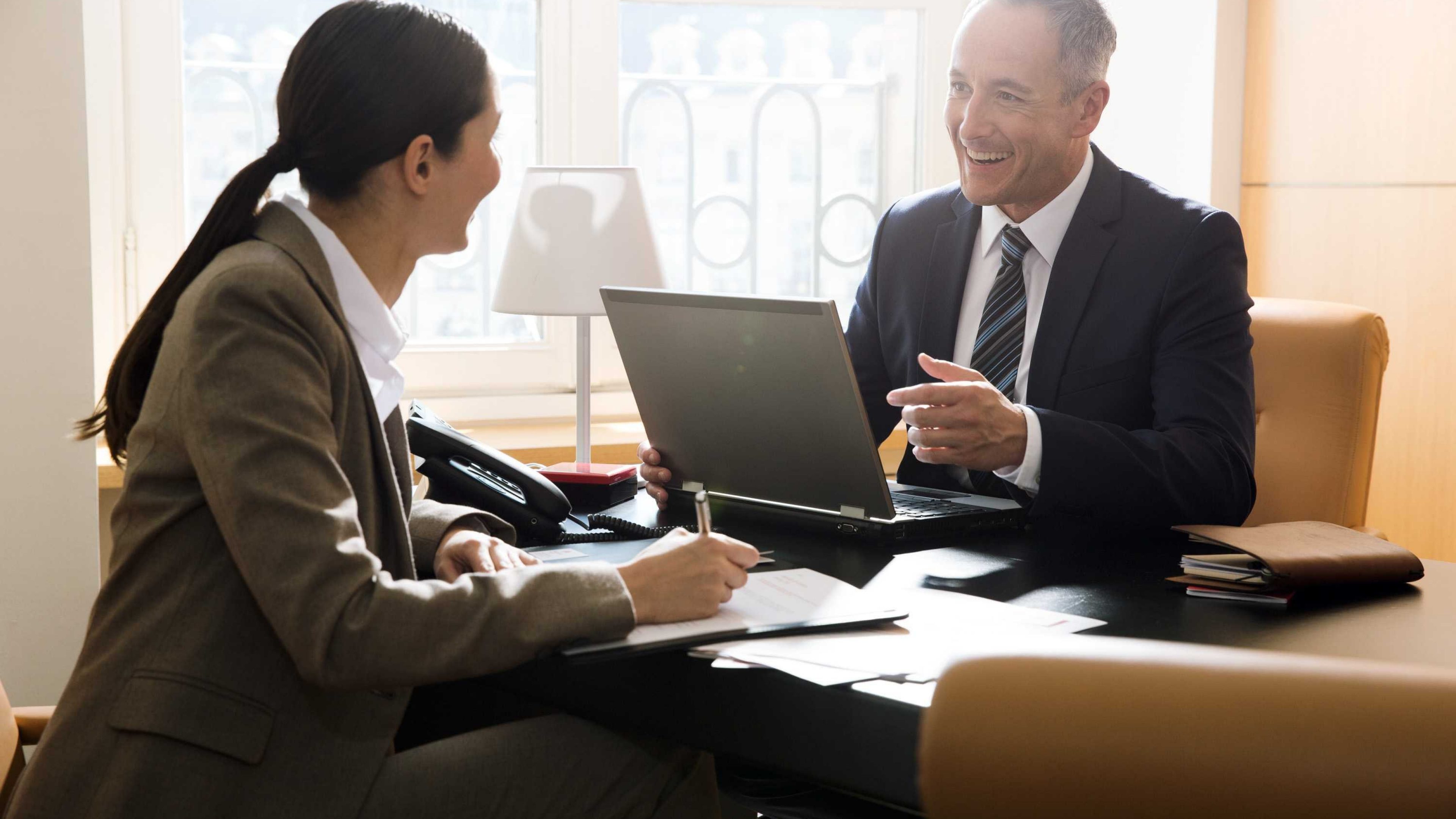 Arbeitskollegen sitzen in einem Büro und besprechen berufliche Vorsorge.