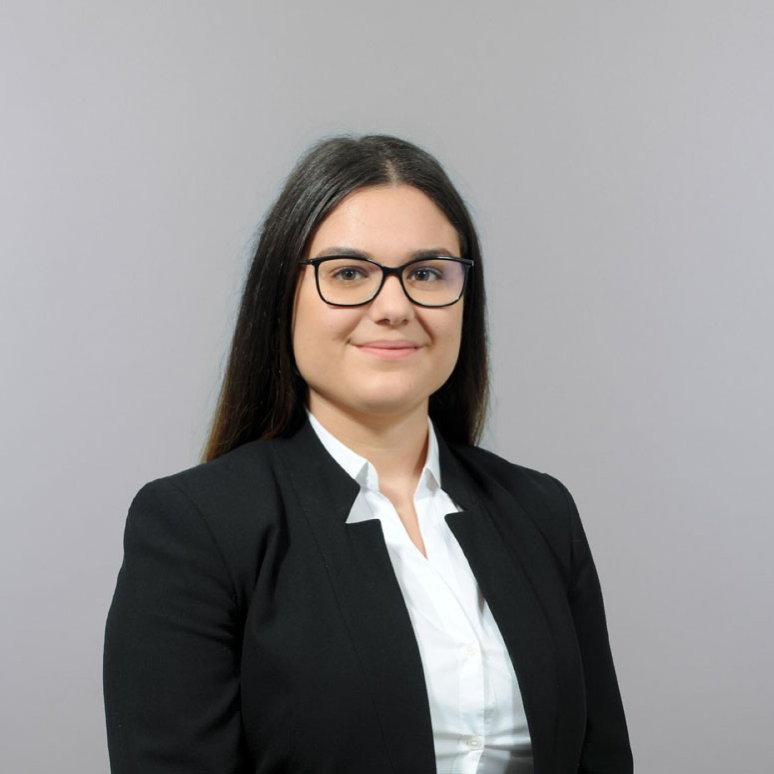 Business picture of a woman with dark hair and glasses.