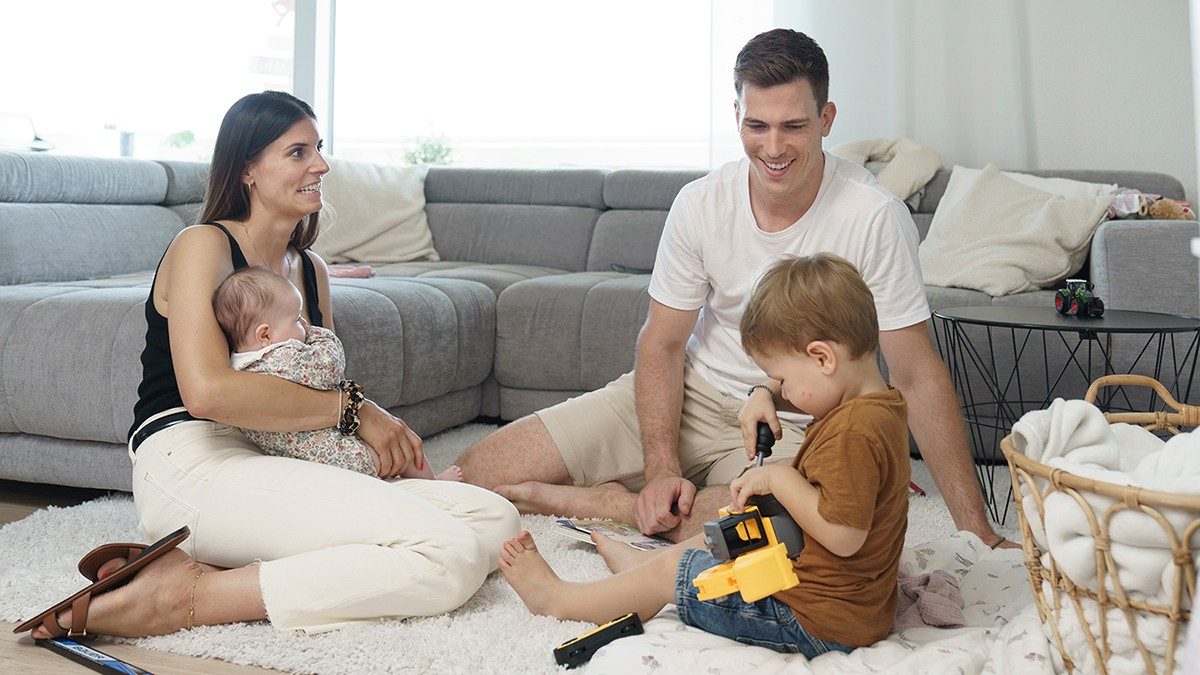 Reto Schäppi sits in the living room with his wife and children.