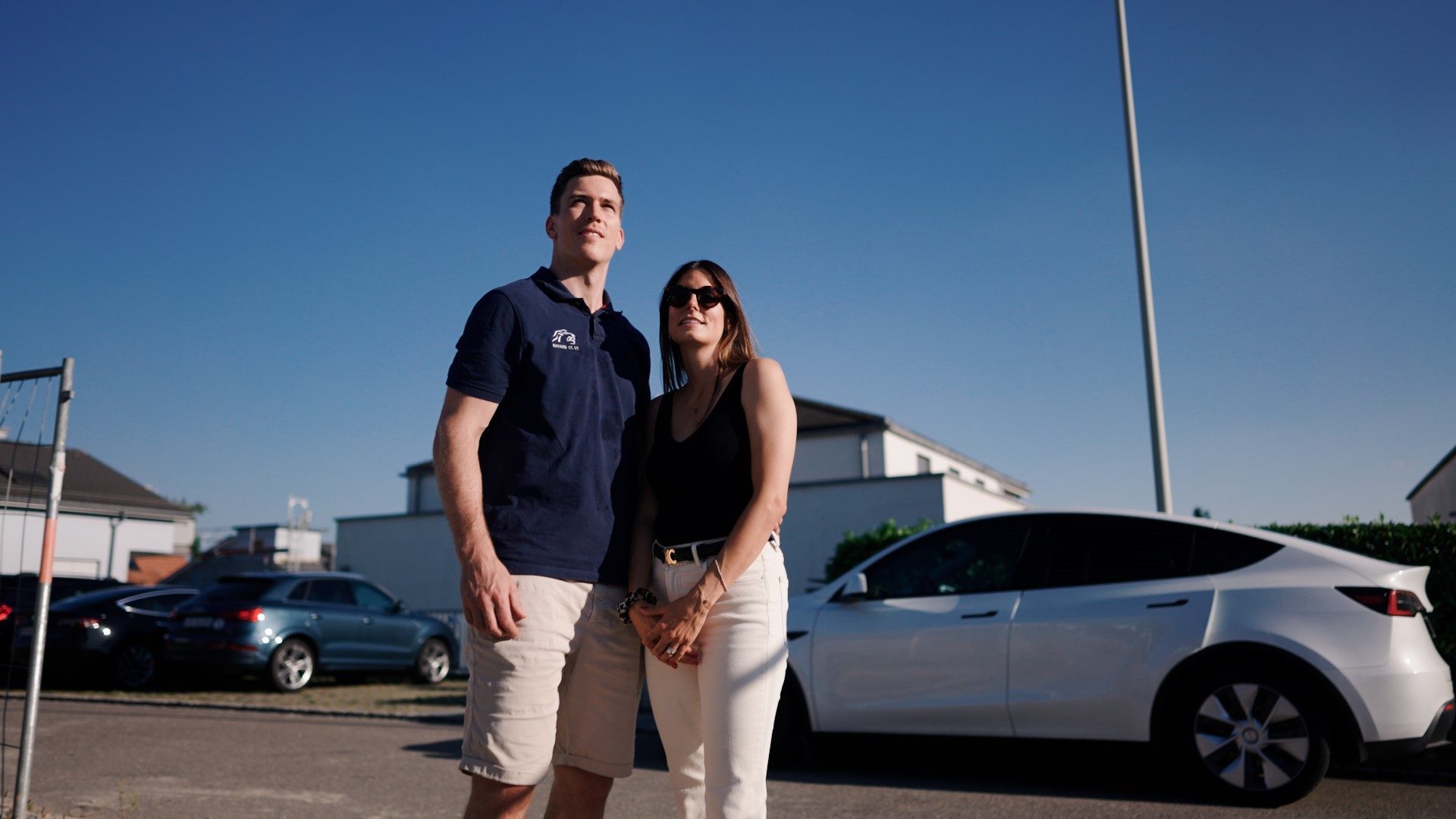 A couple stands on a plot of land on which a house is soon to be built.