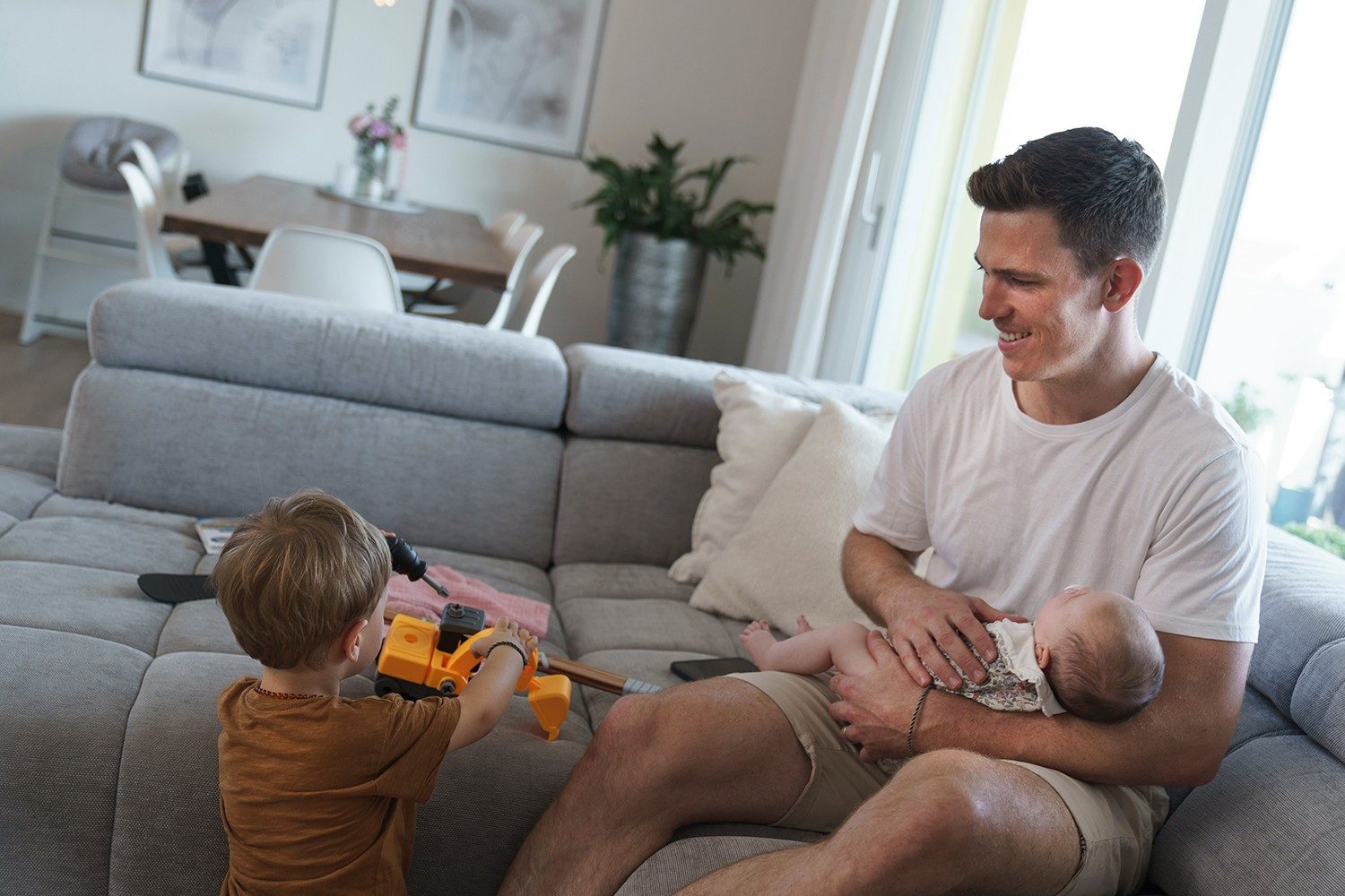 A father plays with his two children.