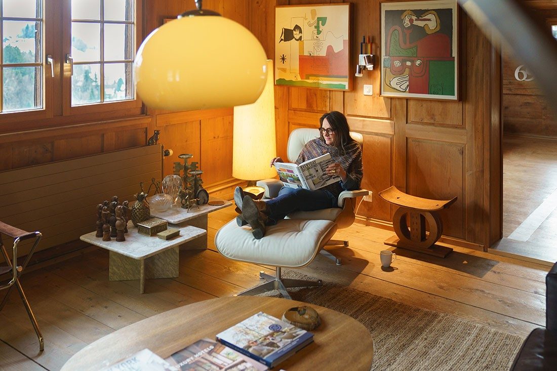 A woman sits in an armchair and reads.