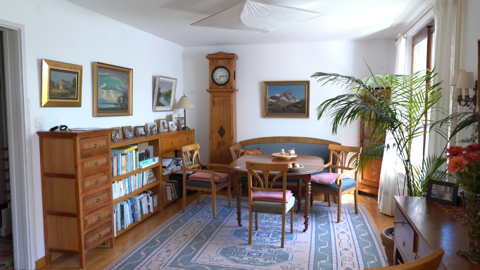 A dining room containing lots of wooden furniture and a rug.