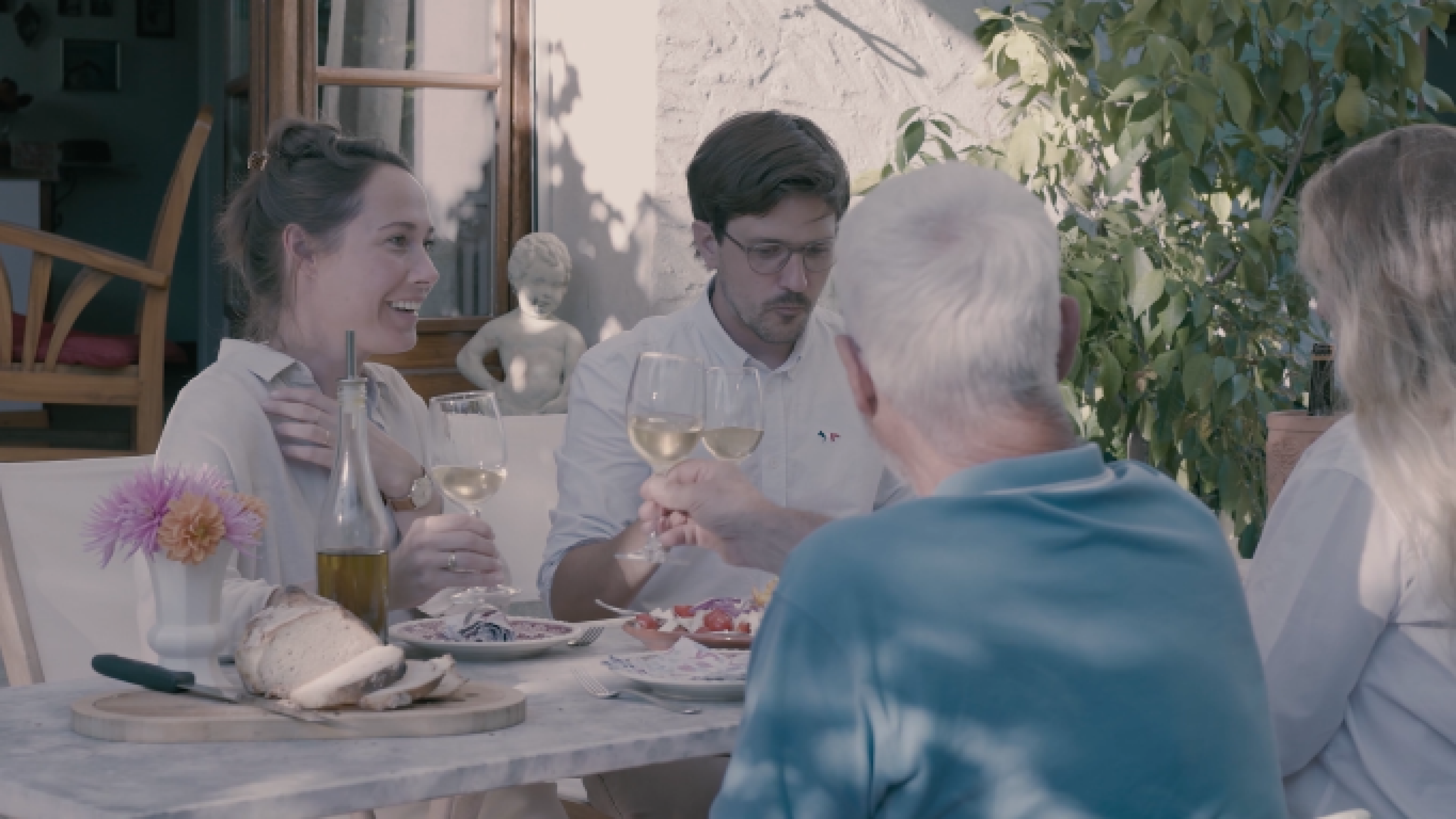 Four people toasting with wine on the terrace 