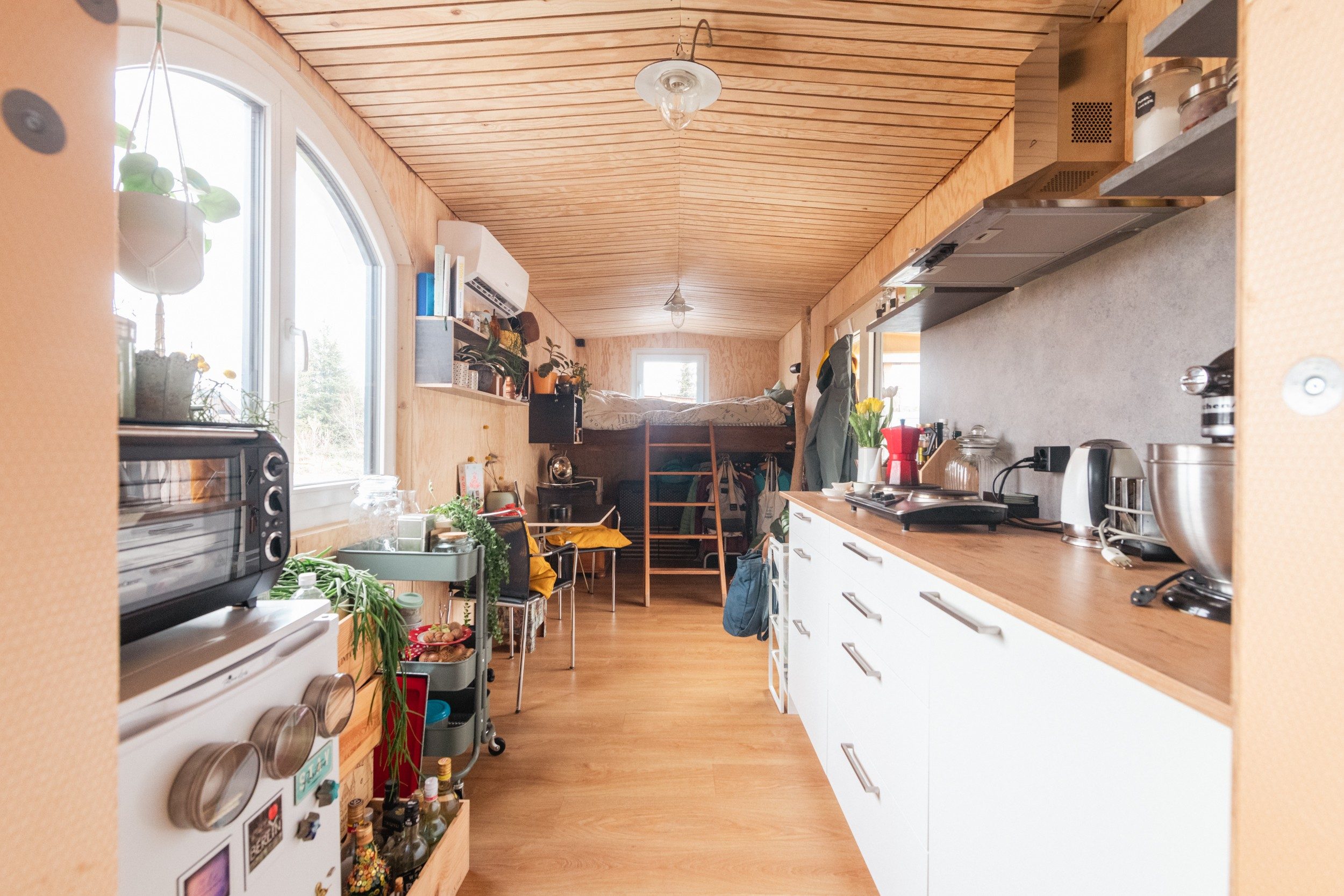 A tiny house with kitchen and bed in one room