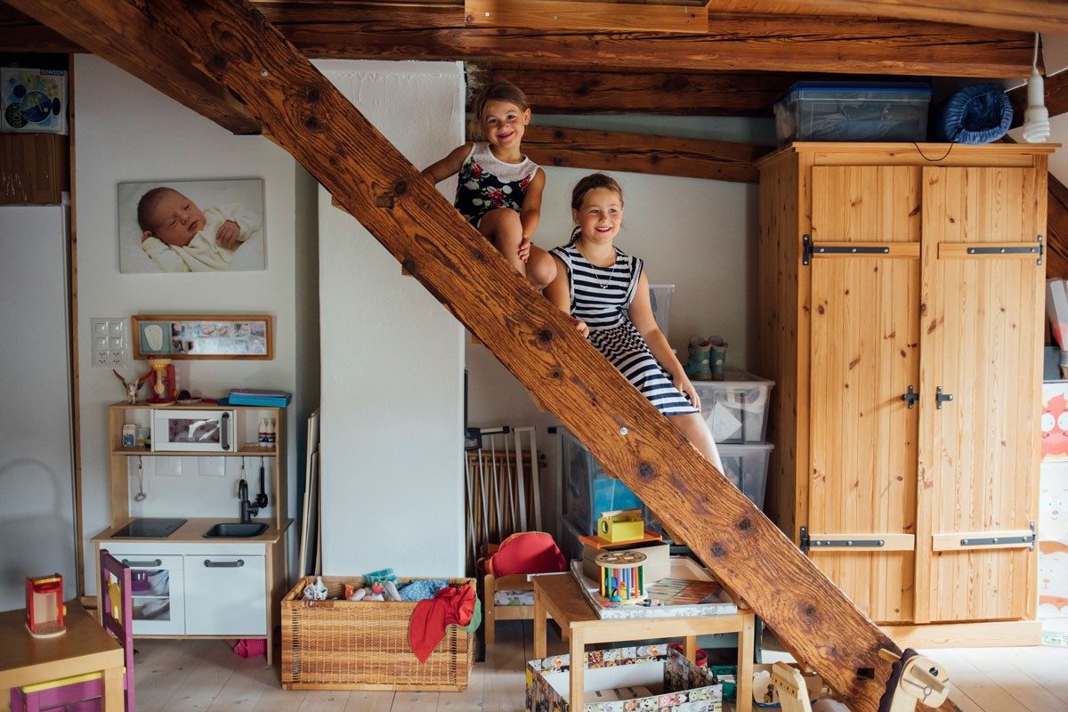 Two girls sitting on a wooden staircase.