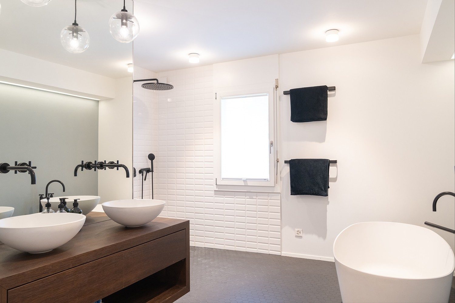 The bathroom is in plain white and black, with a beautiful wooden detail