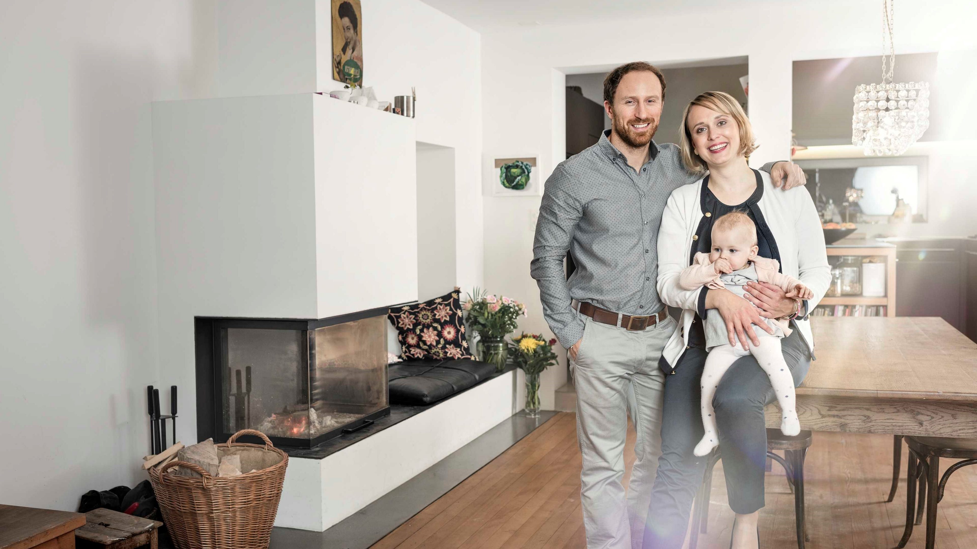 A man and a woman holding a child in a living room