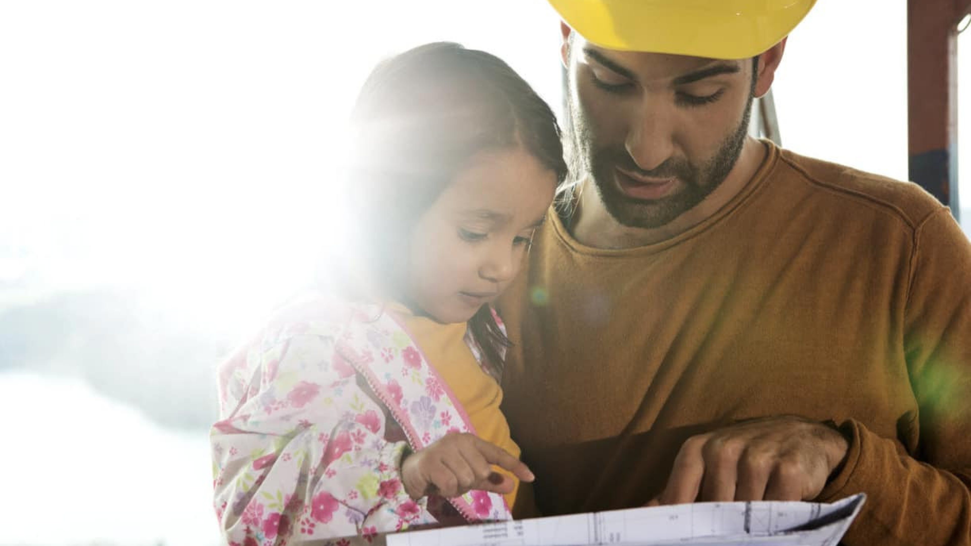 Father explains a blueprint to his little daughter.