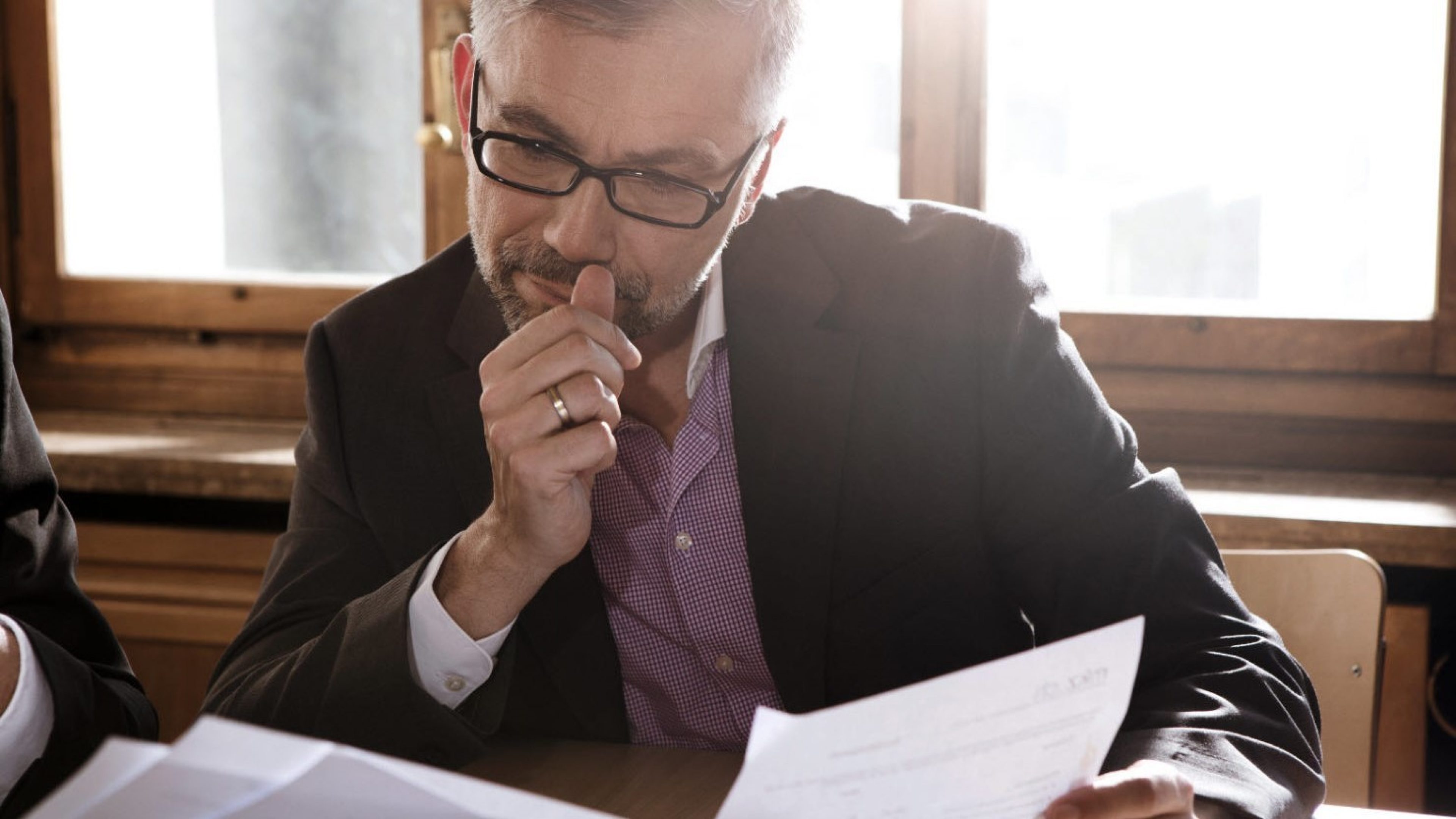 A man sits in the office comparing the options of buying or renting.
