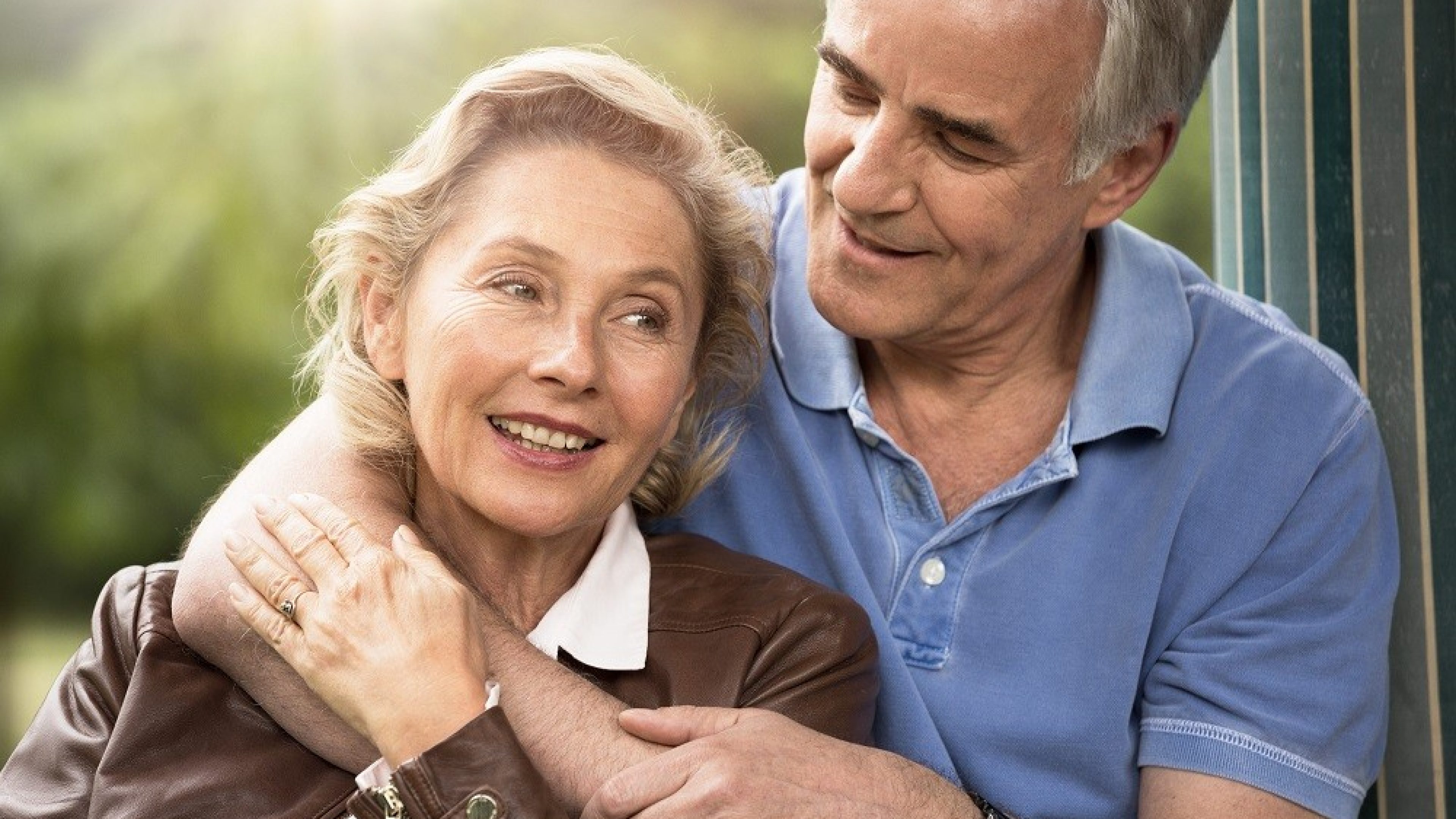 An older couple hugs and discusses transferring their home.