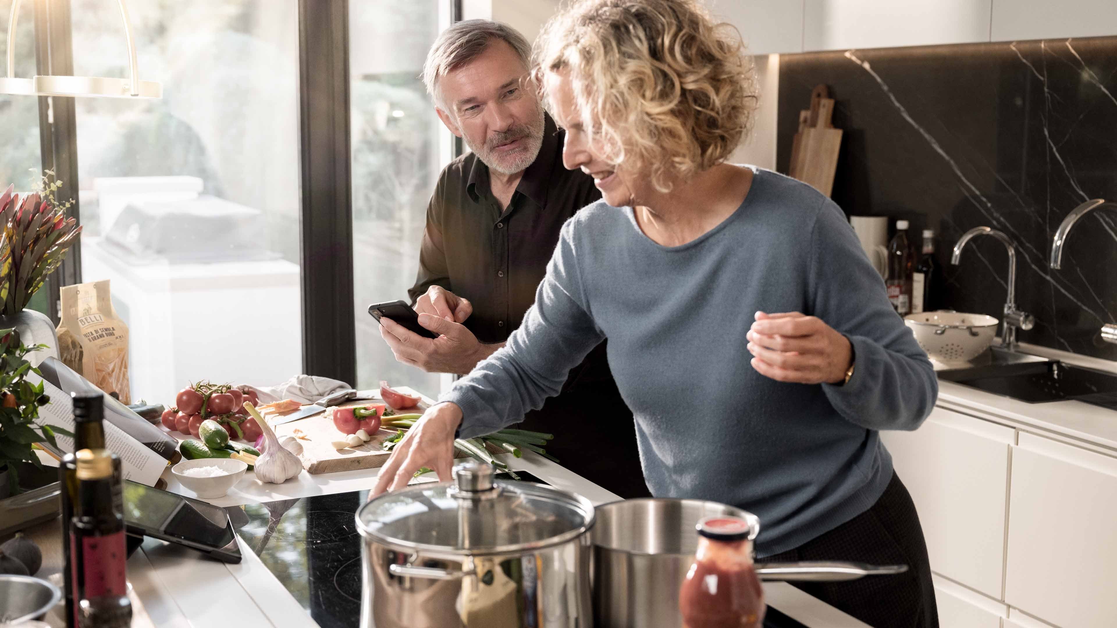 A man and woman cooking a sauce
