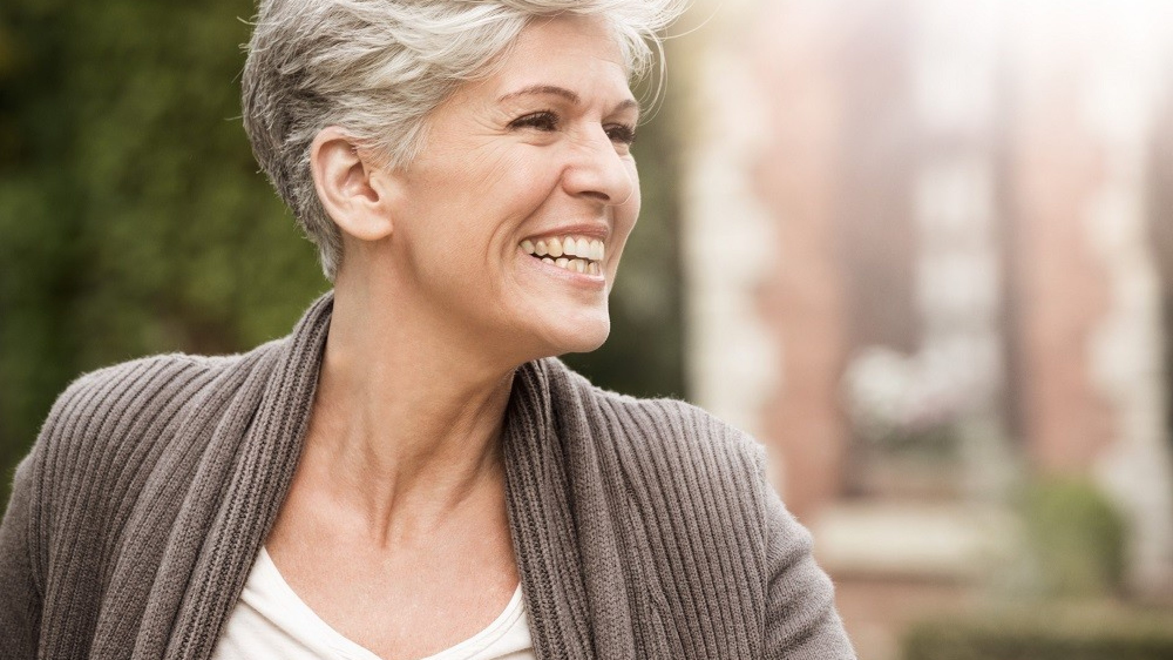A retired woman smiles and rides a bicycle
