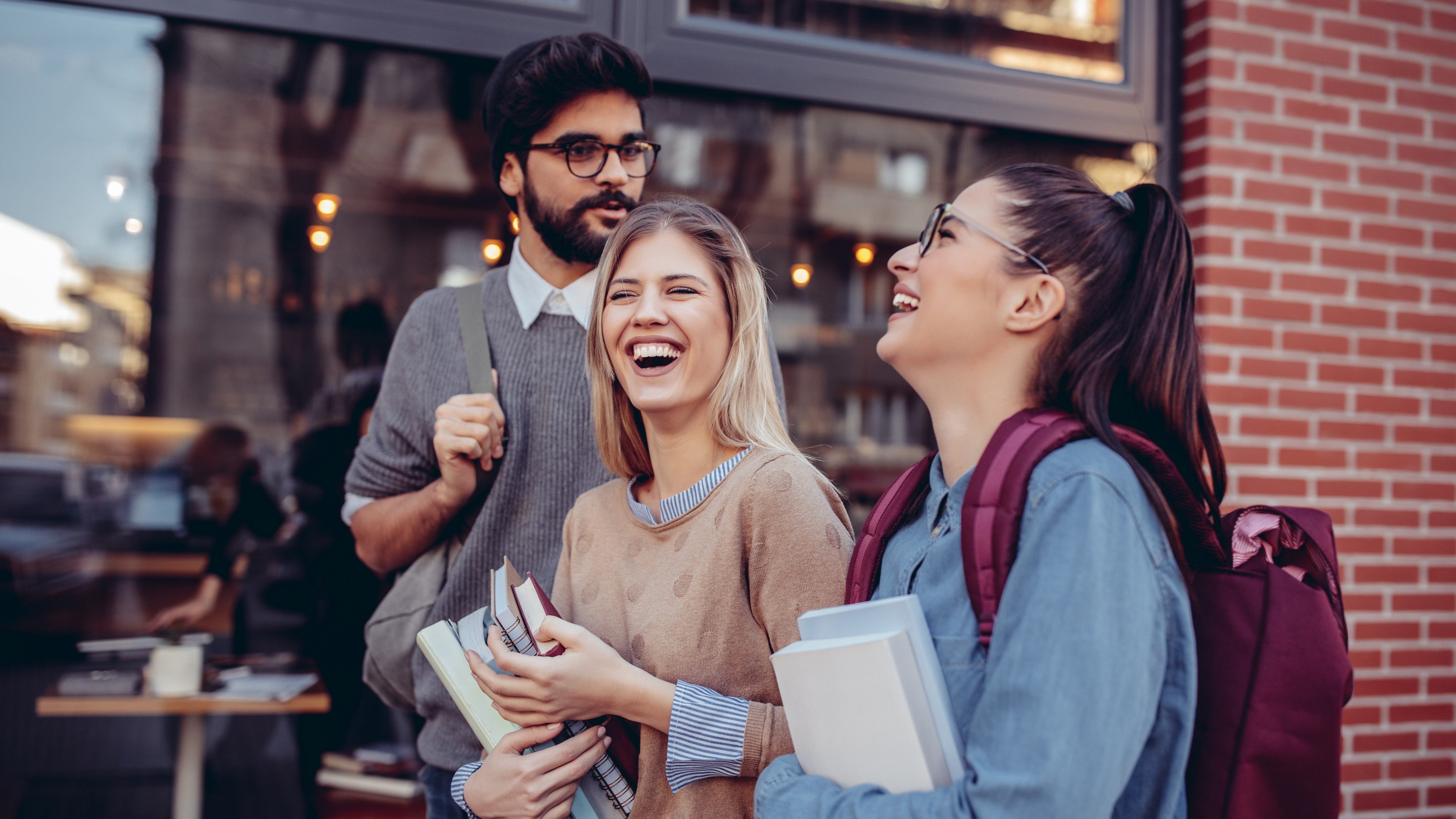Cropped shot of three happy students talking on the street