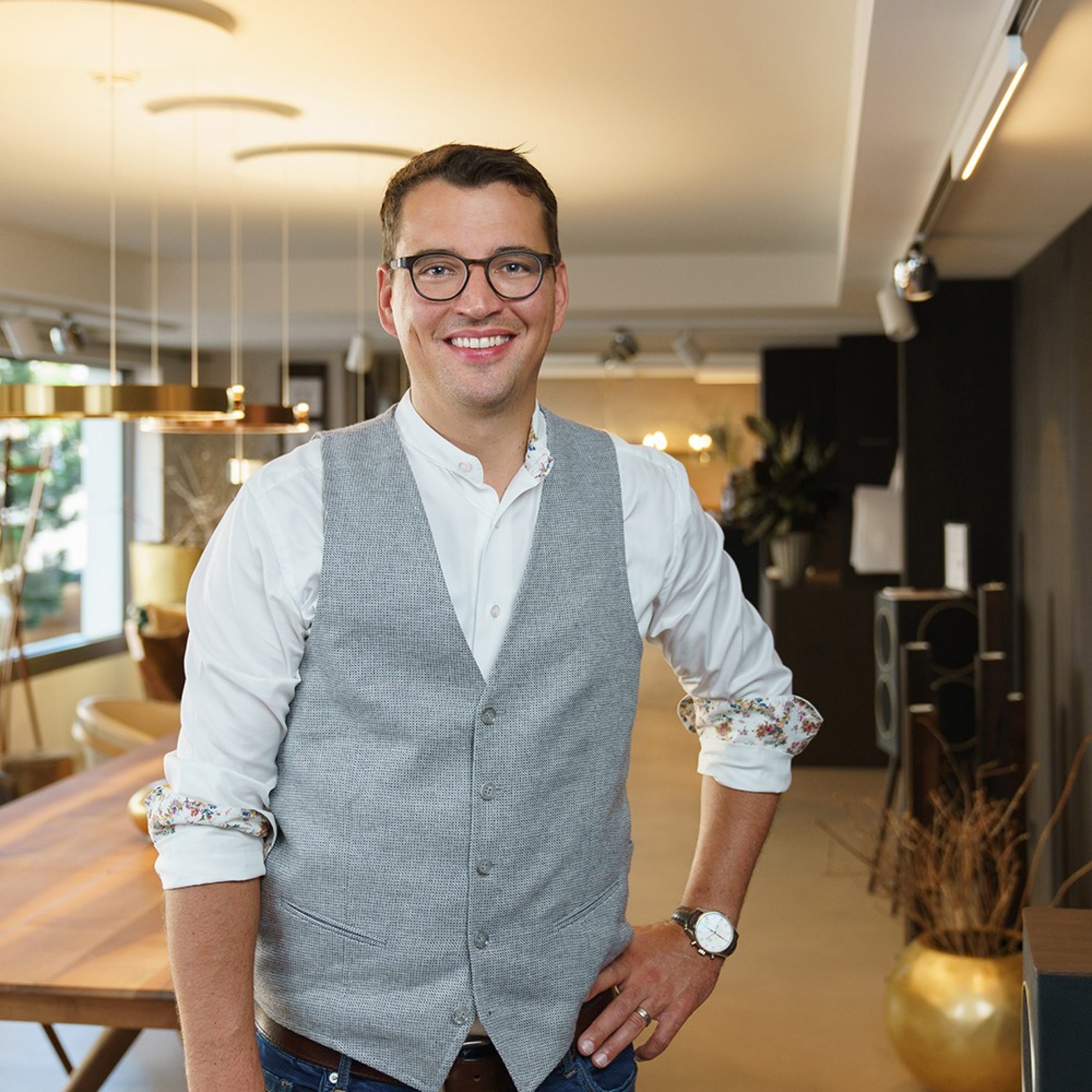 Man stands in a showroom and smiles at the camera