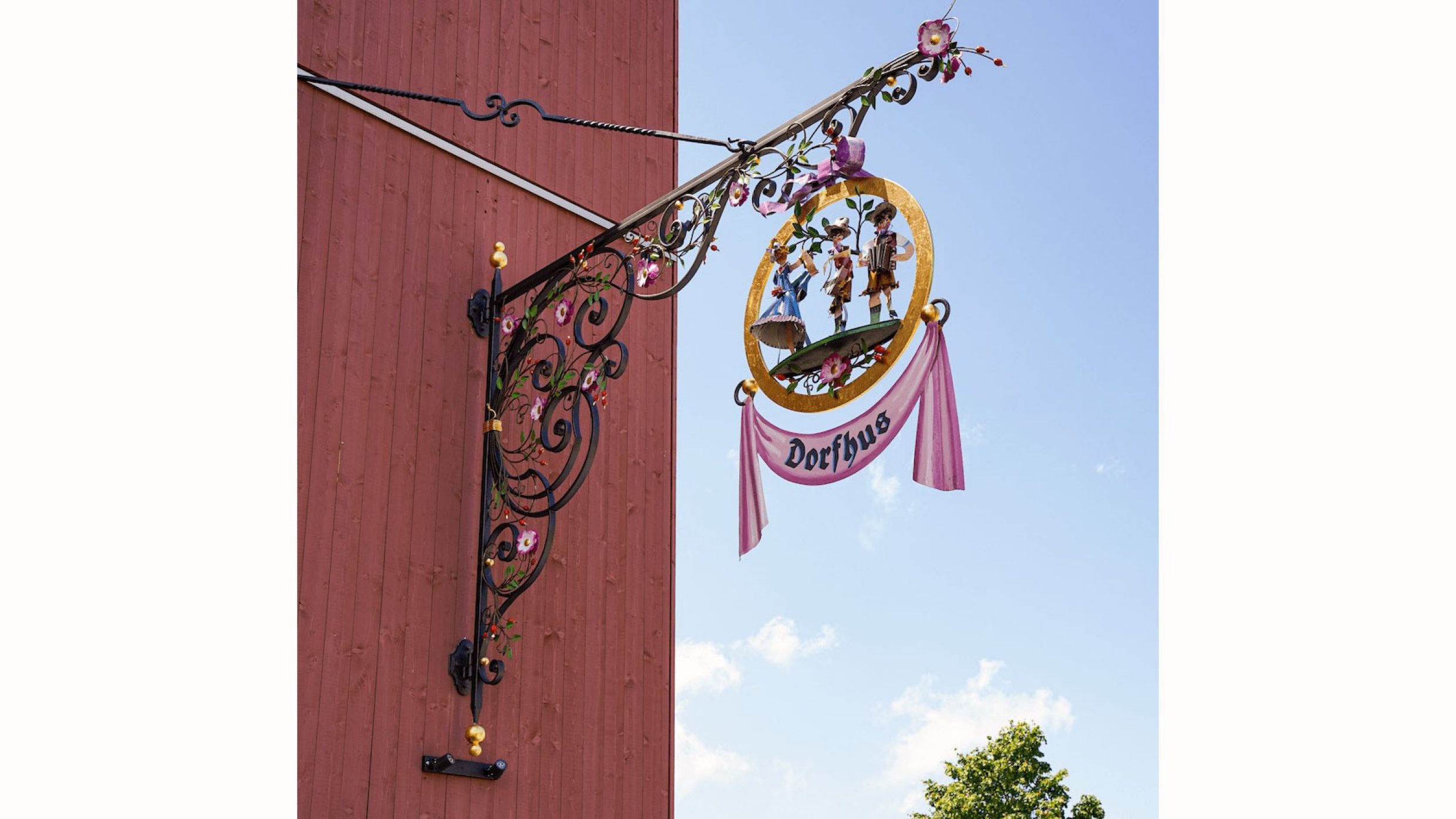 A handmade sign hanging on the facade of a local tavern.