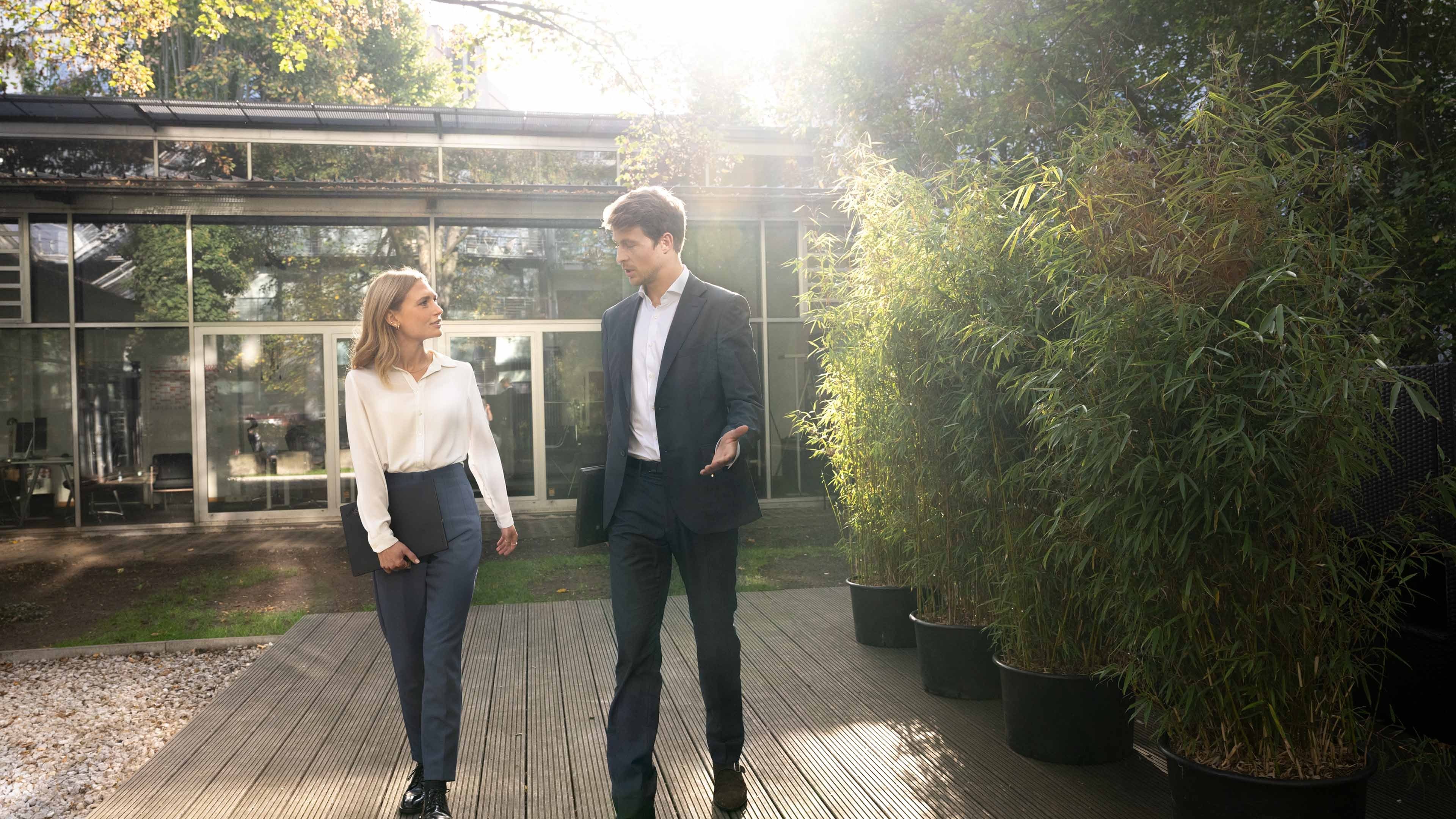 Two employees in conversation outside in the park