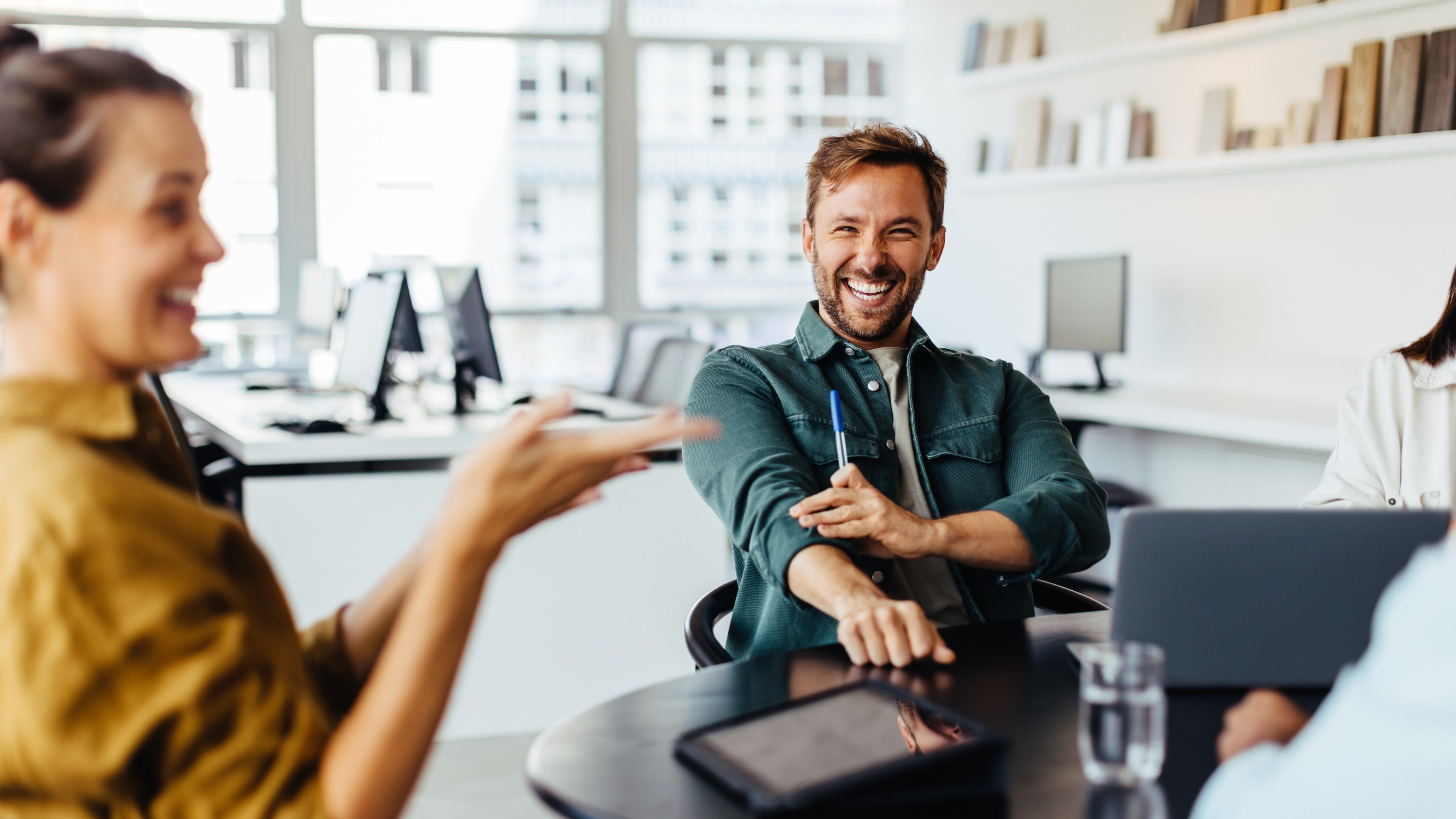 Business people having a team meeting in an office. Group of happy business professionals sitting around a table and having a discussion.