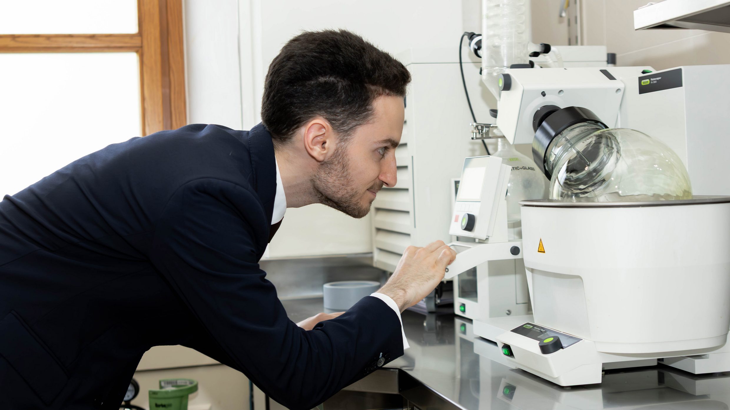 Alexandre Besnault regarde l’évaporateur rotatif dans son laboratoire.