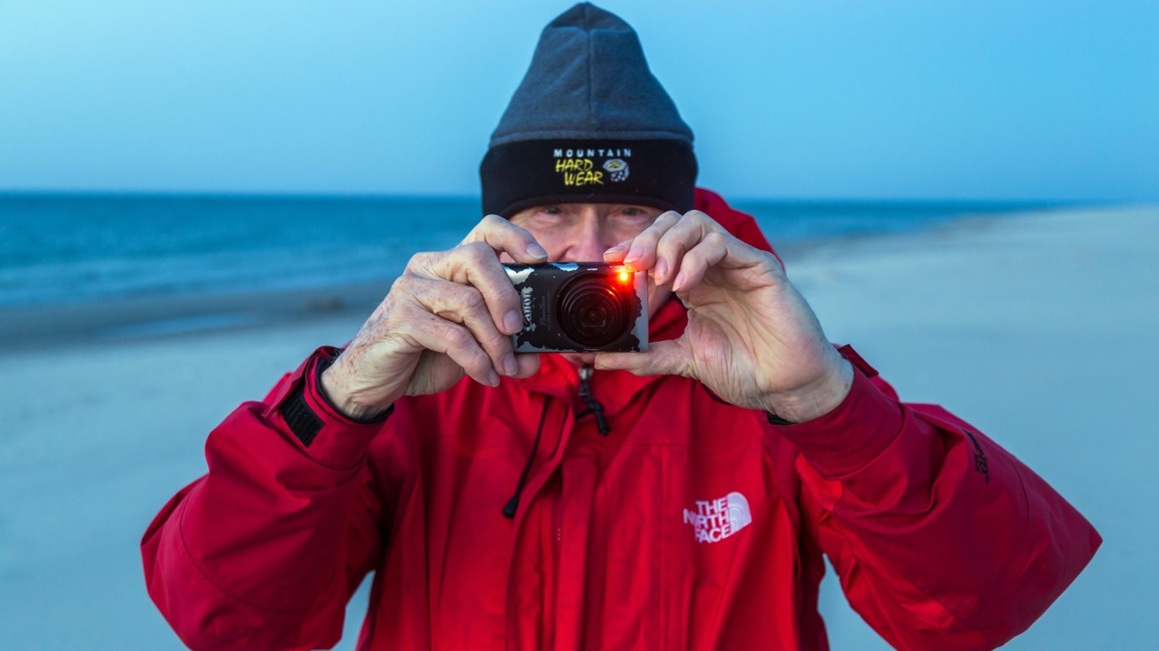 31.05.2014, Kuznica (Kussfeld), Pommern, Polen - Fotografierender amerikanischer Tourist am Ostseestrand nach Sonnenuntergang. Die schmale Halbinsel Hel begrenzt die Danziger Bucht zur Ostsee auf ihrer westlichen Seite, hier die Seite zum offenen Meer. Hel gehoert zu den bekanntesten Reisezielen einheimischer Touristen. / American tourist at dawn on the beach of Hel peninsula. Hel lies in front of the Gdansk Bay (Zatoka Gdanska). 00A140531D059CARO.JPG [MODEL RELEASE: NO, PROPERTY RELEASE: NO (c) Caro Fotoagentur / Andreas Bastian, Friedrich-Karl-Str. 13, 12103 Bln., Tel. 030-75706507, Fax 030-75706508, http://www.carofoto.com, info@carofoto.com, Bln. Spk., IBAN: DE23 1005 0000 1440 0403 00, BIC: BELADEBEXXX - Bei Verwendung des Fotos ausserhalb journalistischer Zwecke bitte Ruecksprache mit der Agentur halten - Jede Nutzung des Fotos ist honorarpflichtig !]