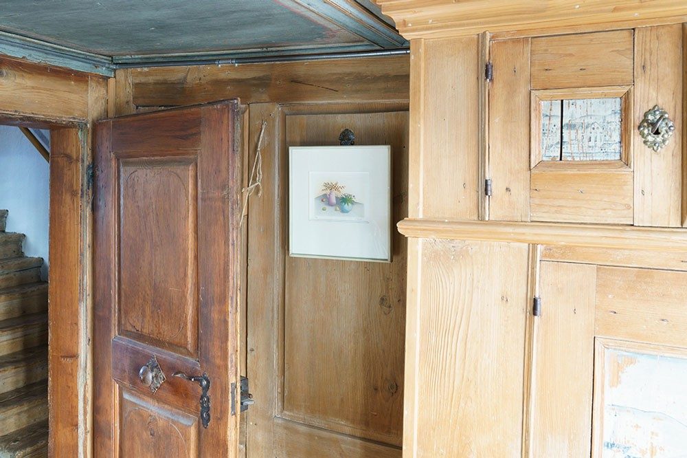 Une chambre avec des murs anciens en bois et une porte antique en bois.