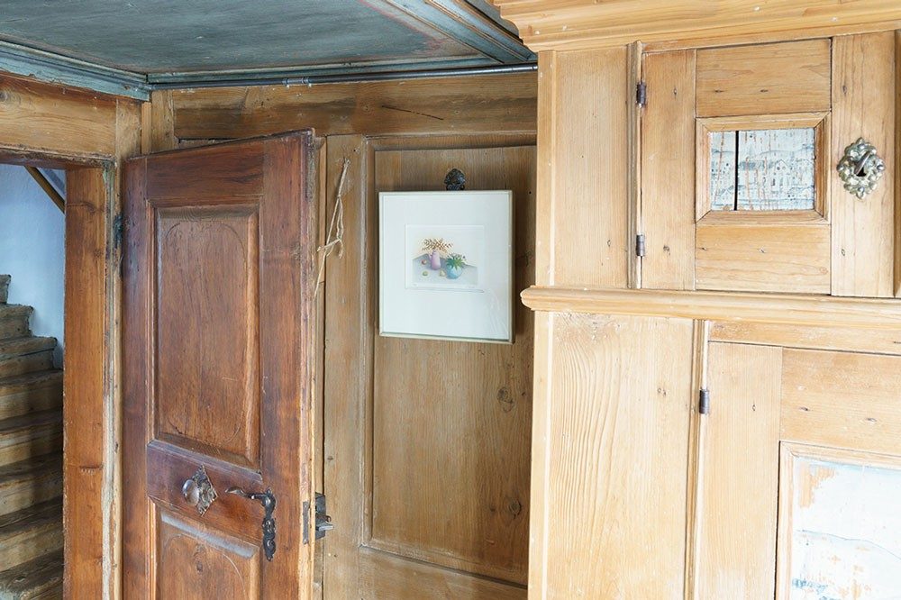 Une chambre avec des murs anciens en bois et une porte antique en bois.